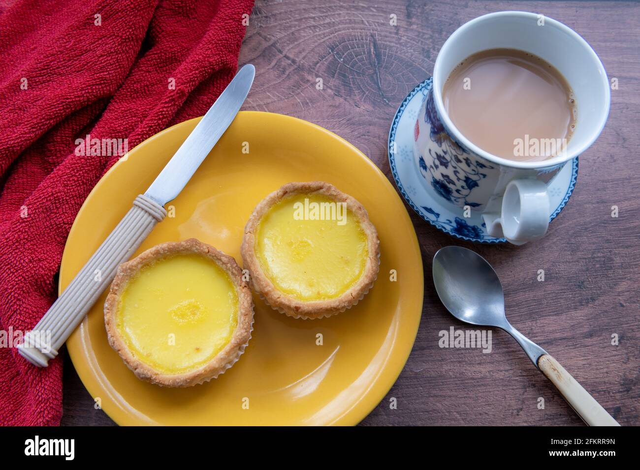 Eiertörtchen auf einem Tisch, serviert mit einer Tasse Tee. Stockfoto