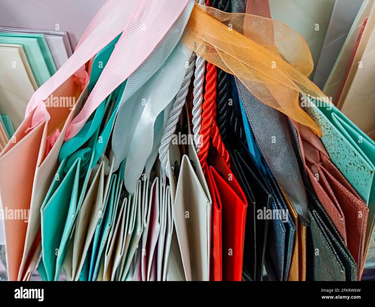 Mehrfarbiger Geschenkpapiere auf der Ladentheke, mehrfarbige Papiertüten mit Bändern Stockfoto