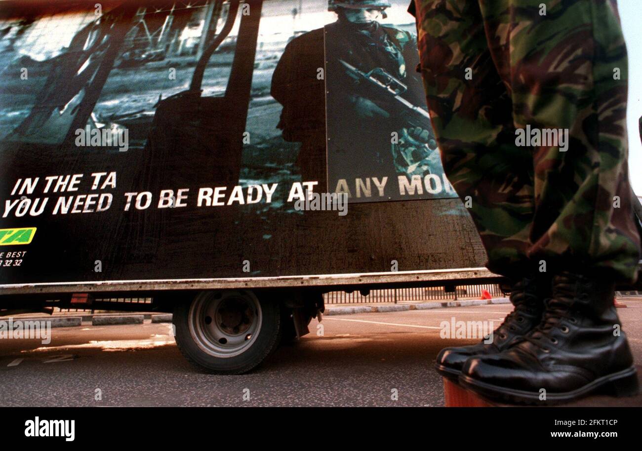 NEUE REKRUTIERUNGSKAMPAGNE FÜR DIE TERRITORIALE ARMEE, DIE AUF DER MOD IN LONDON GESTARTET WURDE. EIN SOLDAT GEHT AN EINEM DER NEUEN PLAKATE VORBEI. Stockfoto