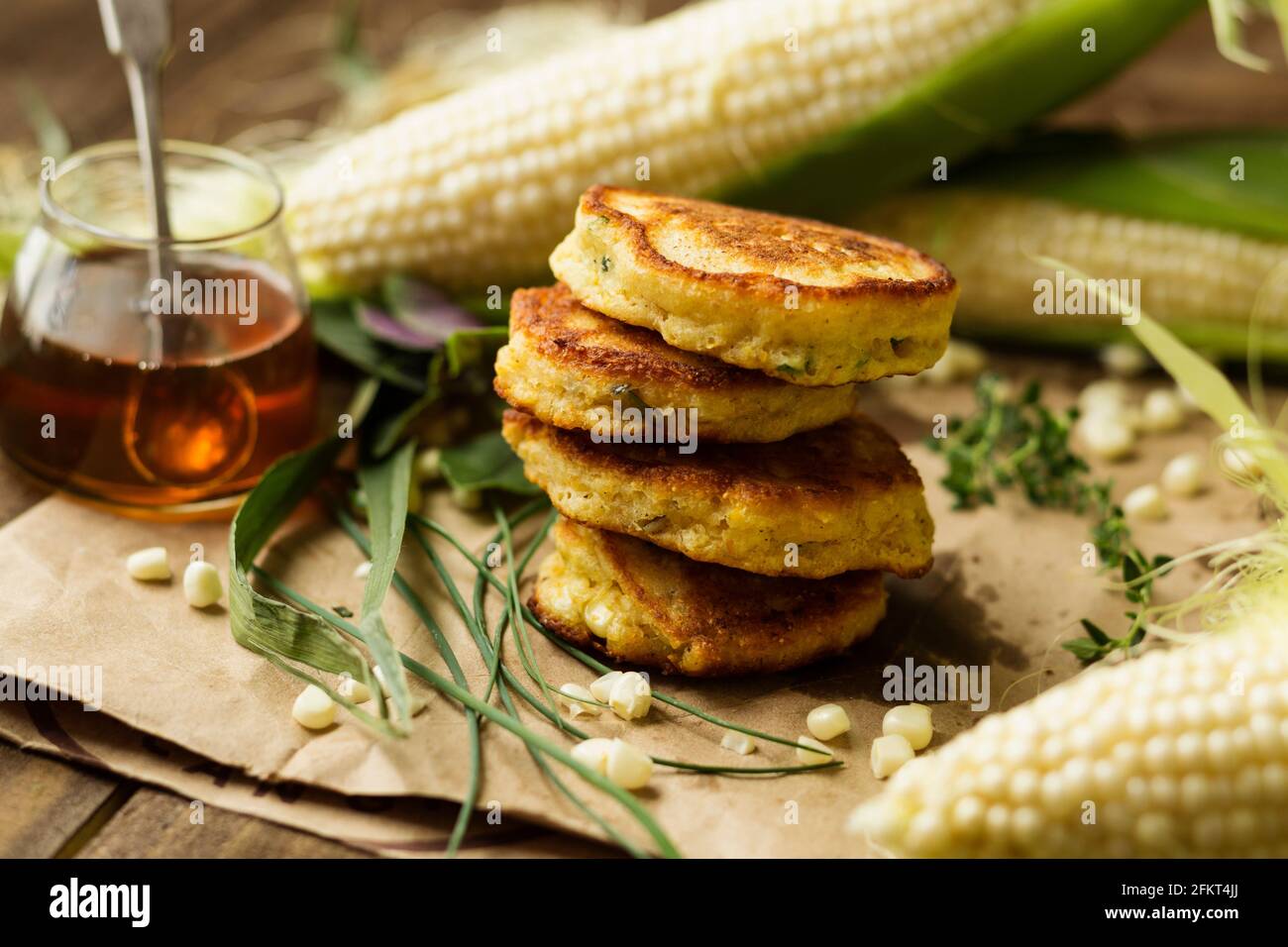 Stapel von Mais Krapfen mit Honig und Mais Maiskolben am Küchentisch Stockfoto