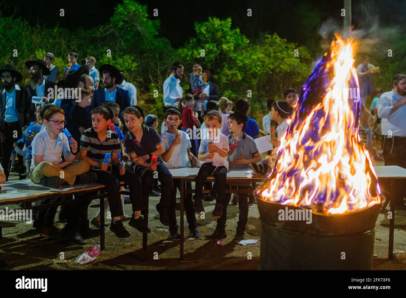 Haifa, Israel - 29. April 2021: Ultraorthodoxe Juden feiern den Feiertag lag BaOmer, während sich die Kinder um ein Feuer versammelten. Haifa, Israel Stockfoto