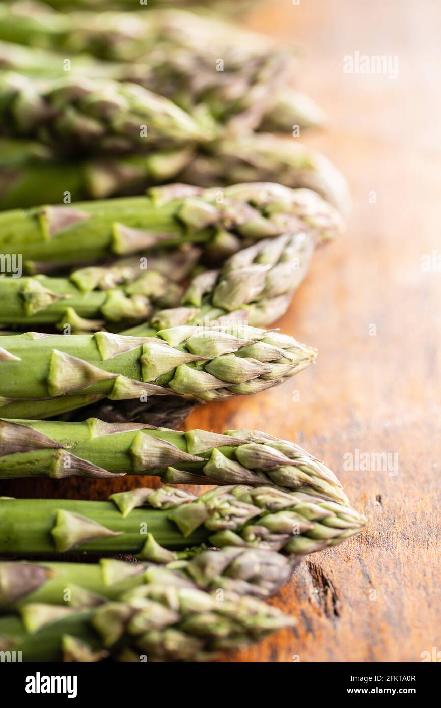 Frischer roher, ungekochter grüner Spargel auf dem Holztisch. Stockfoto