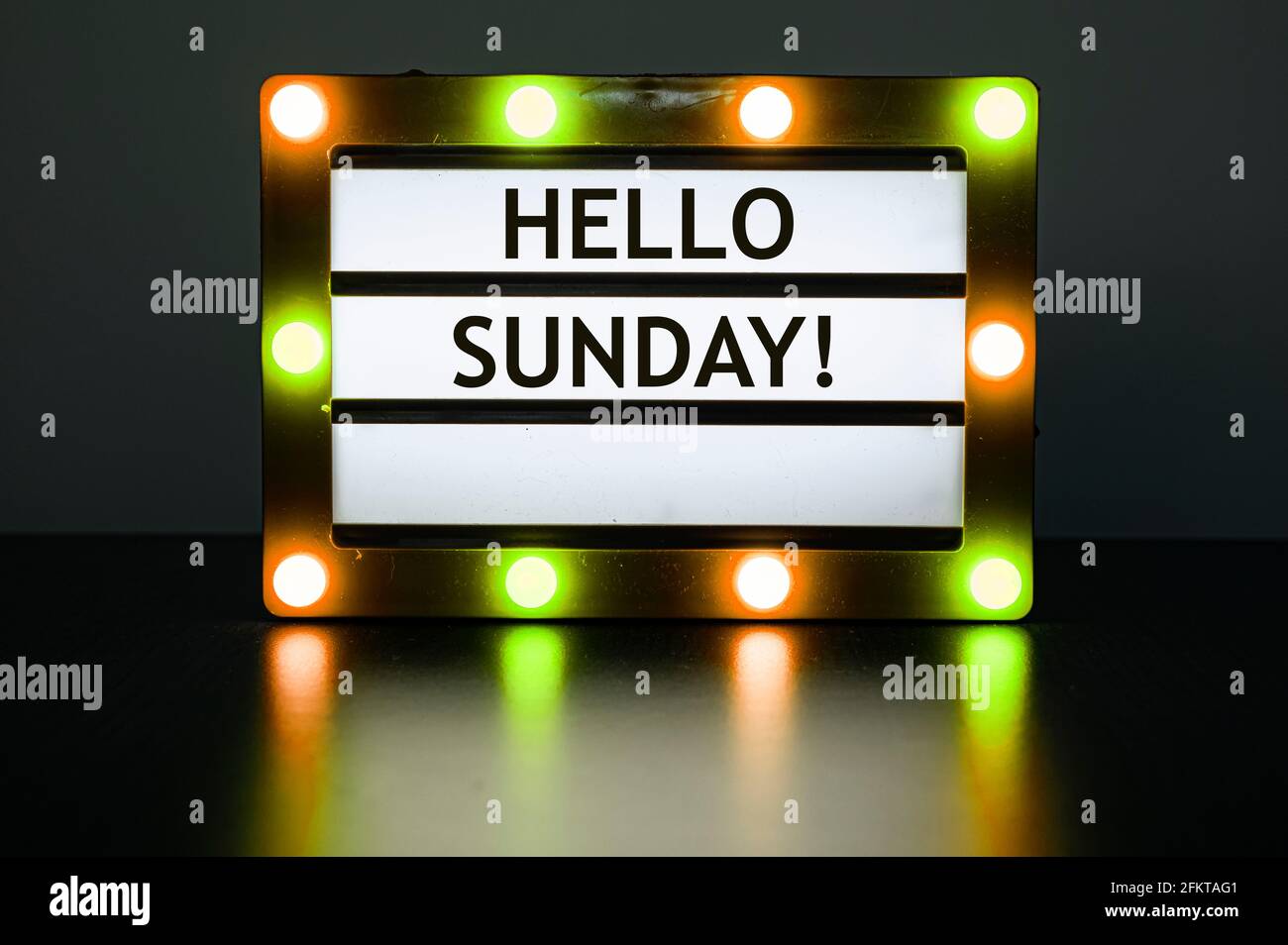 Leuchtkasten mit gelben und orangen Lichtern im dunklen Raum mit Worten - Hallo Sonntag! Stockfoto
