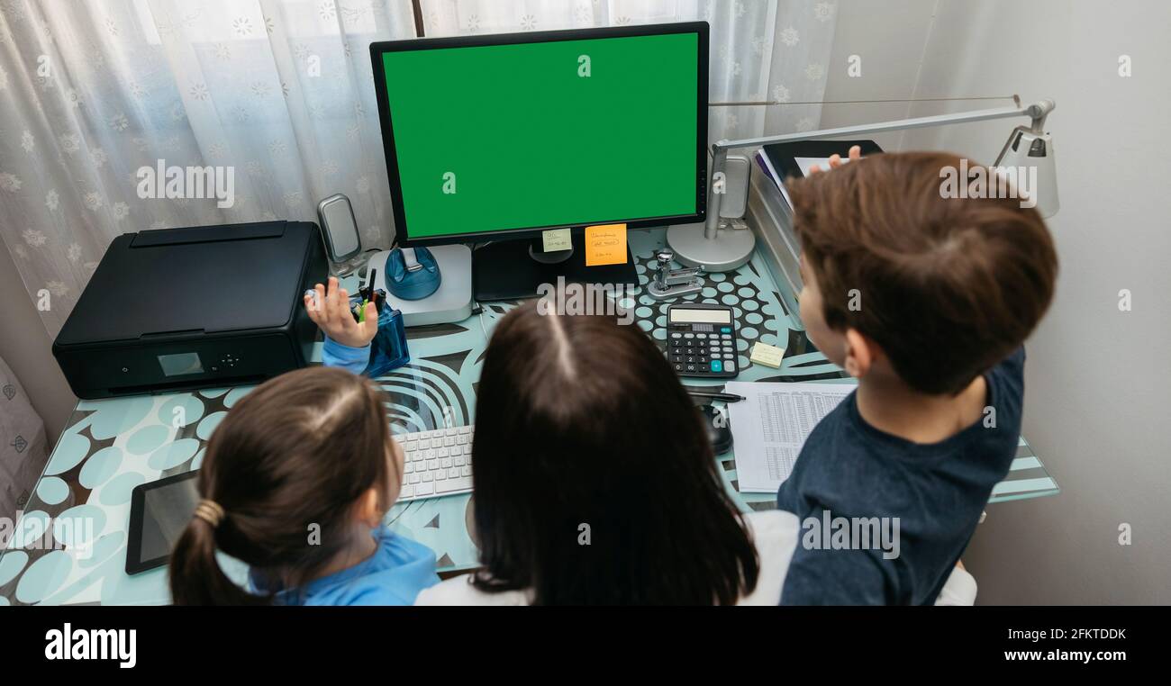 Mutter und Kinder, die auf den Computerbildschirm schauen Stockfoto