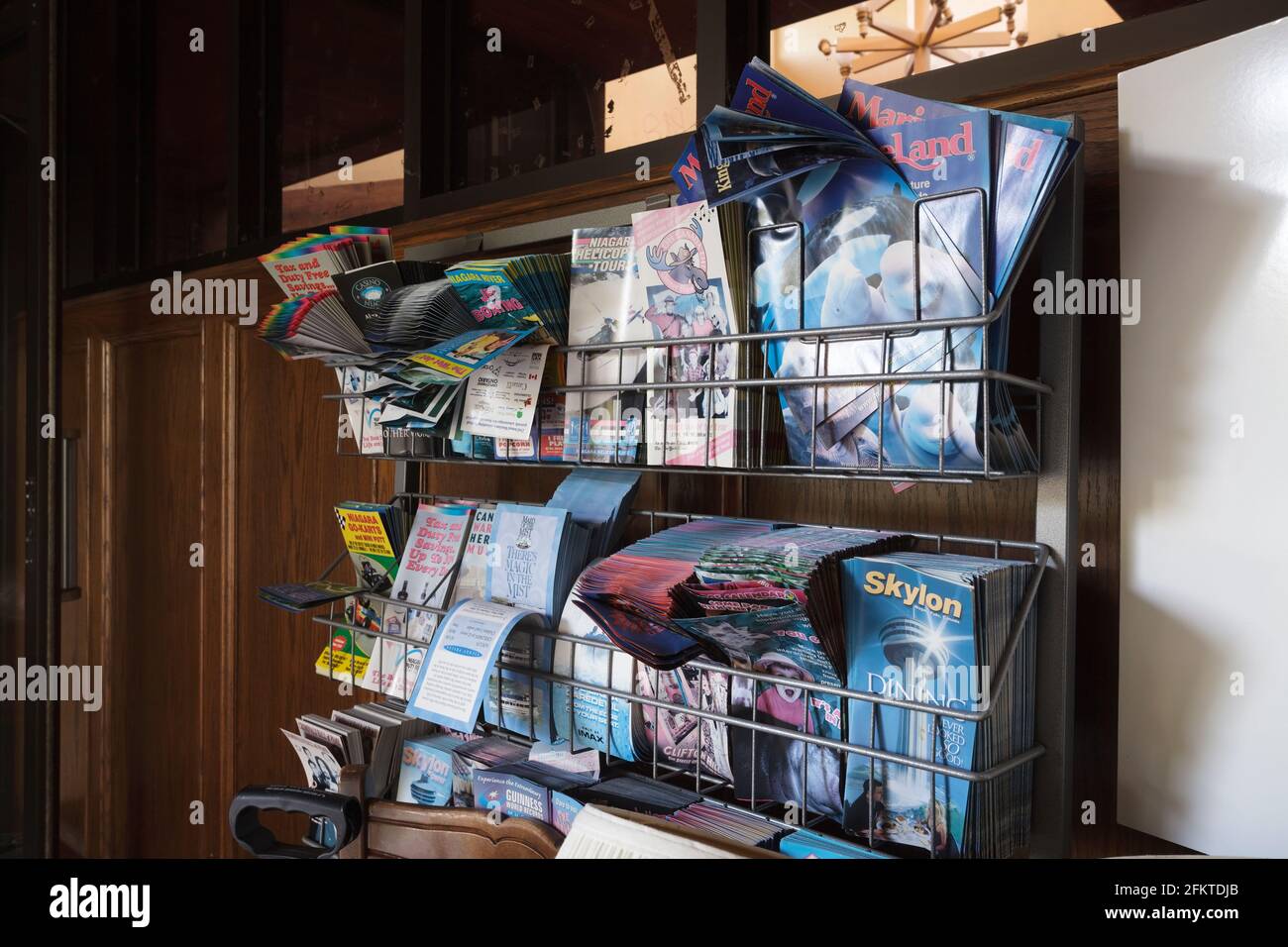 Touristenbroschüre, die von der Sonne beschädigt wurden, auf einem Drahtgitter in einer verlassenen Motellobby. Dieses Gebäude wurde abgerissen und nicht mehr ex Stockfoto