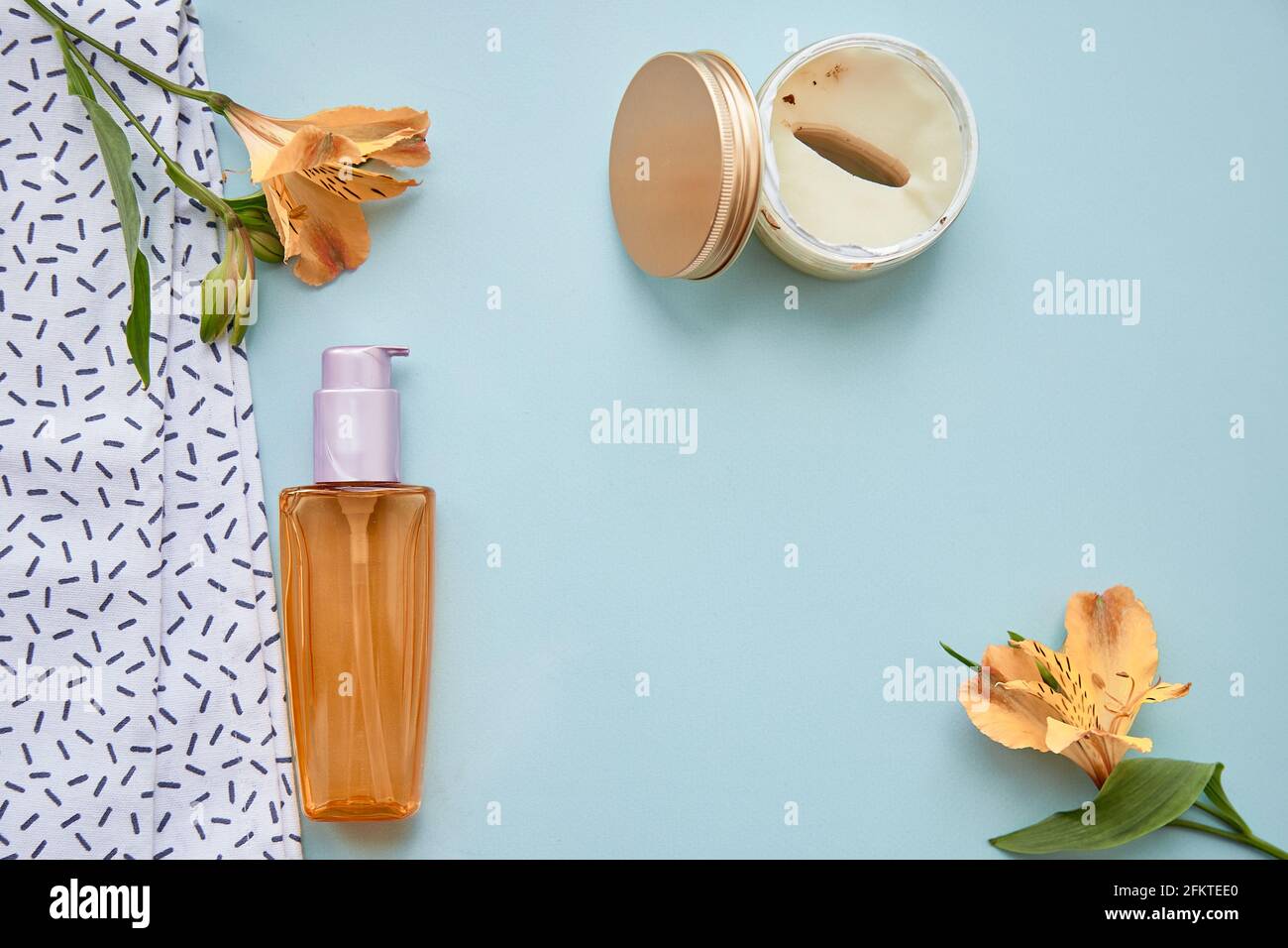 Beauty-Konzept mit kosmetischen Accessoires auf blauem Hintergrund. Kosmetische Flasche Mockup, Patches und Alstroemeria Blumen. Hochwertige Fotos Stockfoto