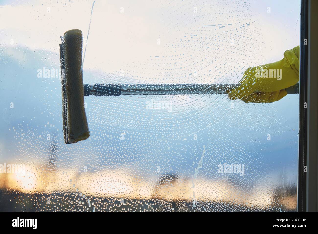 Frühjahrsputz. Fenster waschen. Hausarbeit, ein Mann reinigt sein Haus. Desinfektion während der Quarantäne durch Coronavirus. Speicherplatz kopieren. Hochwertige Fotos Stockfoto