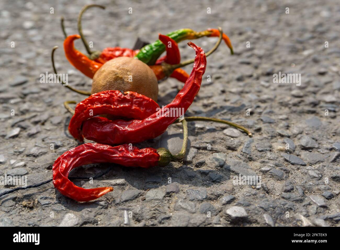 Zitronen-Chili-Bündel auf der Straße. Eine alte Praxis des Werfens von Zitrone und Chili Bündel als Teil des Tabus in INDIEN, um Pech gehabt. zu vermeiden Stockfoto