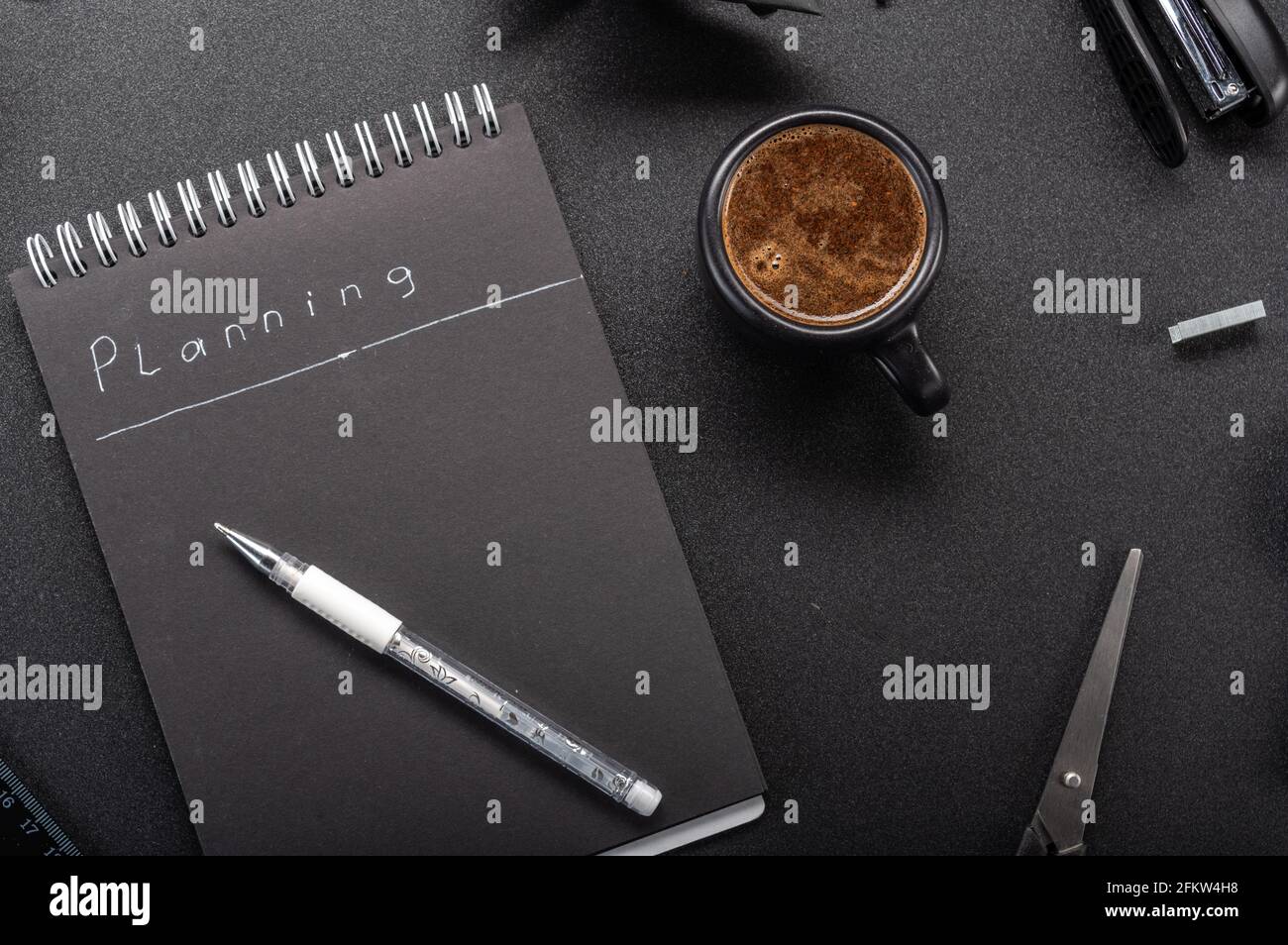 Kaffee auf dem Schreibtisch. Notizbuch für die Planung. Journal für das Halten von Plänen. Notebook und Kaffee. Oben. Stockfoto
