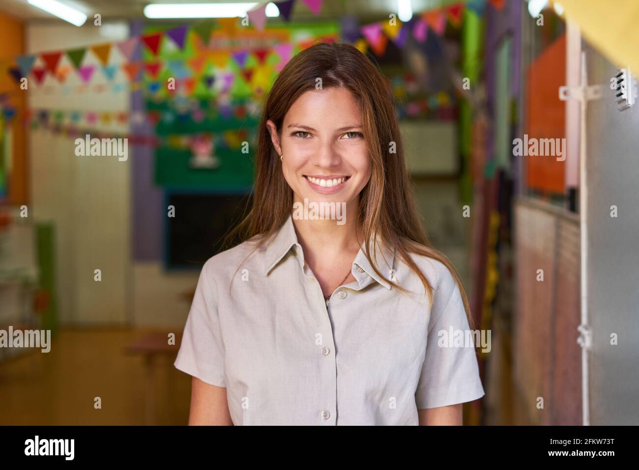Freundliche junge Frau als Lehrerin oder Kindergärtnerin in Kindergarten oder Vorschule Stockfoto