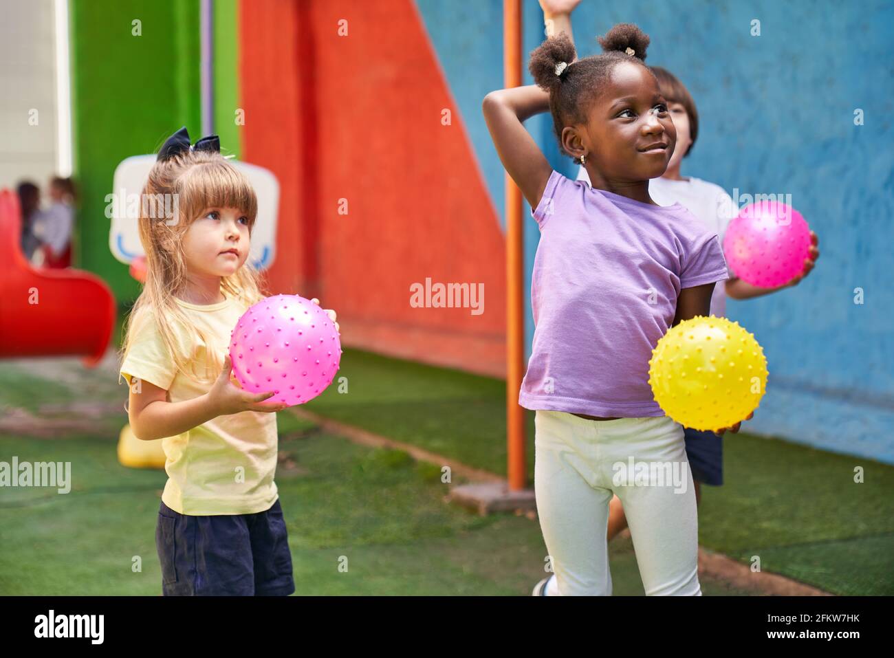 Gruppe multikultureller Kinder, die gemeinsam in der Kindertagesstätte Ball spielen Klasse Stockfoto