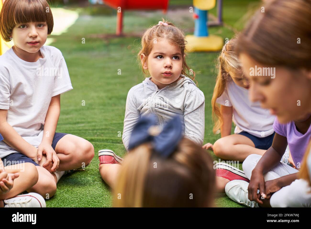 Gruppe von Kindern und Erzieher im Gespräch im Kindergarten oder Kindertagesstätte Stockfoto