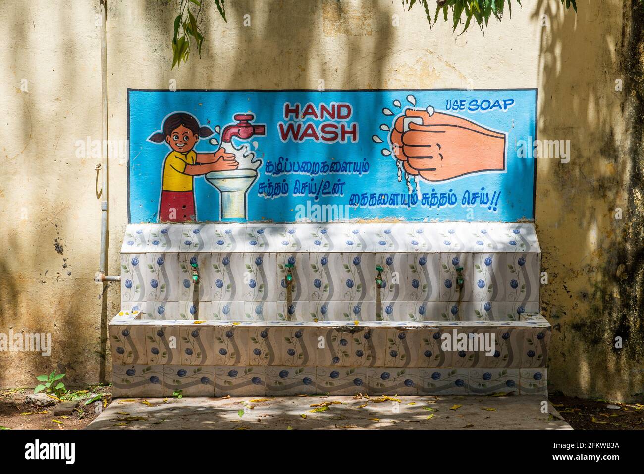 Tamil Nadu, Indien - März 2021: Handwäsche gegen Covid-Infektion. Großes Wandbild auf dem Schulhof einer Grundschule. Stockfoto