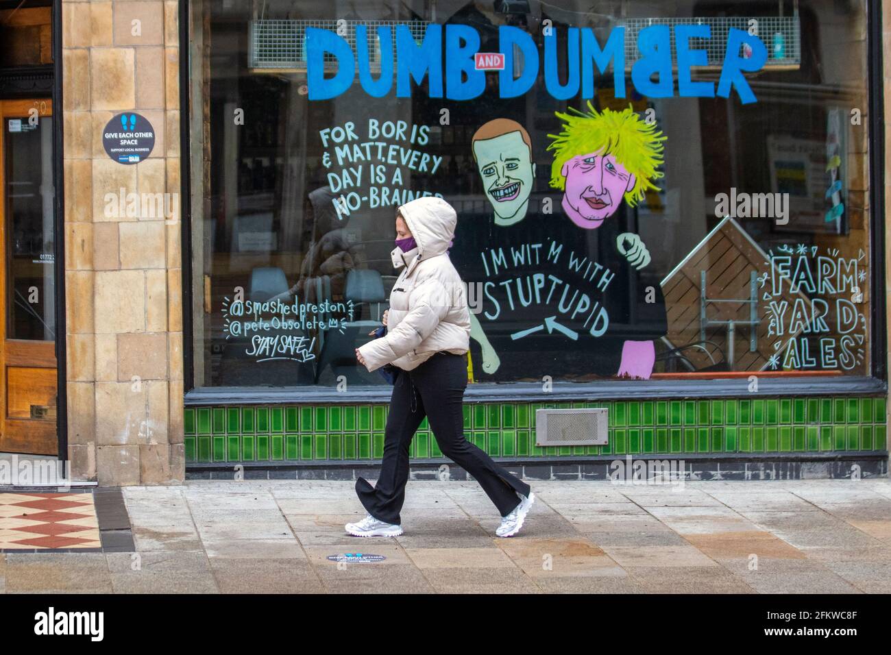 Boris Johnson Tory Führer Cartoon-Bilder in Preston; Lancashire. Mai 2021; UK Wetter; Anoraks wasserdichte Jacken und Regenmäntel sind an einem kalten, nassen und windigen Tag an der Tagesordnung. Satire, Comic, Karikaturen, satirische politische Cartoons, Parodie im Stadtzentrum. Stockfoto