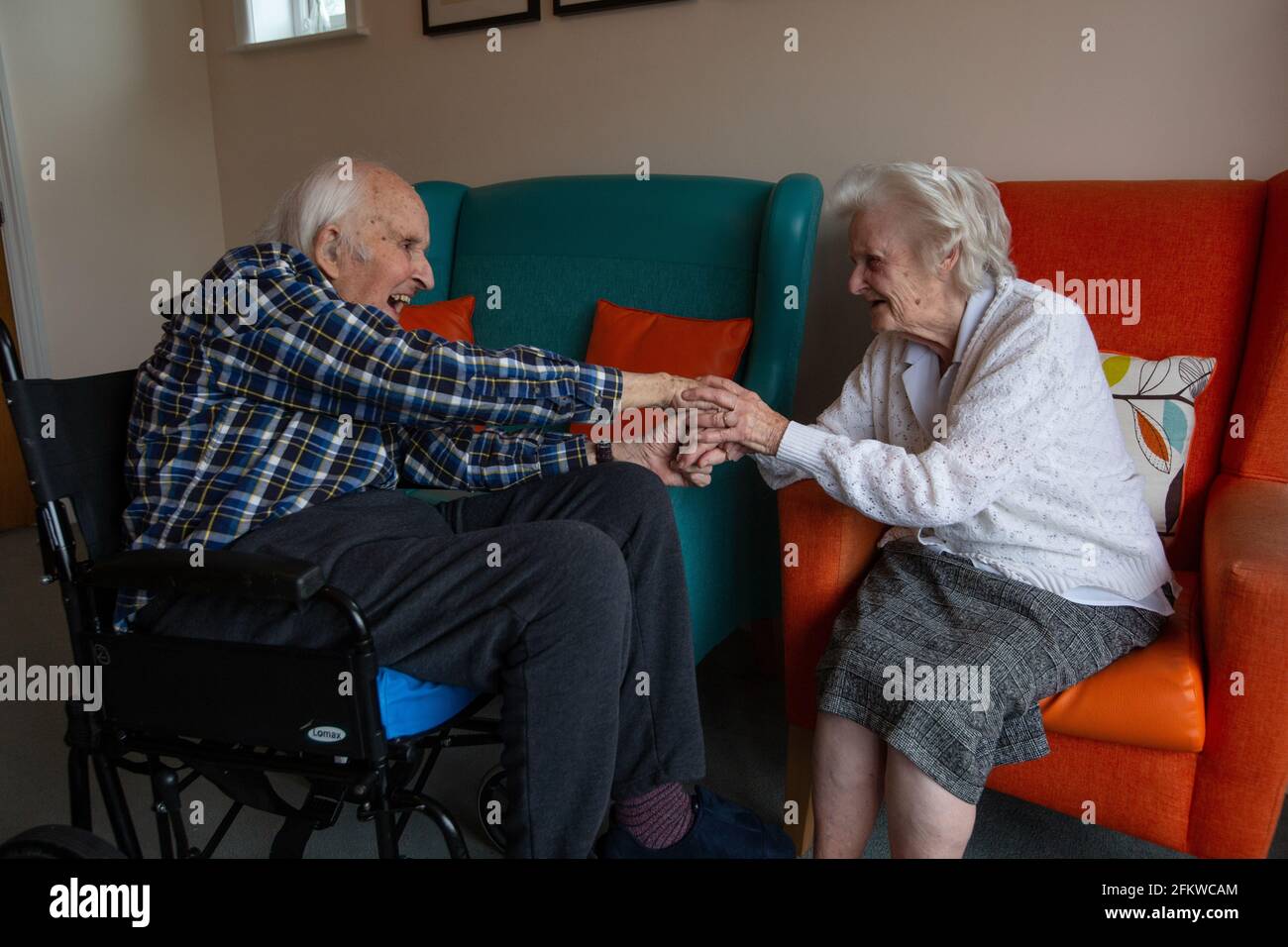 Ein älteres Paar in den Achtzigern, das nach einer mehrwöchigen Trennung aufgrund der Coronavirus-Pandemie, Hampshire, England, wieder in einer Pflege vereint wurde. Stockfoto