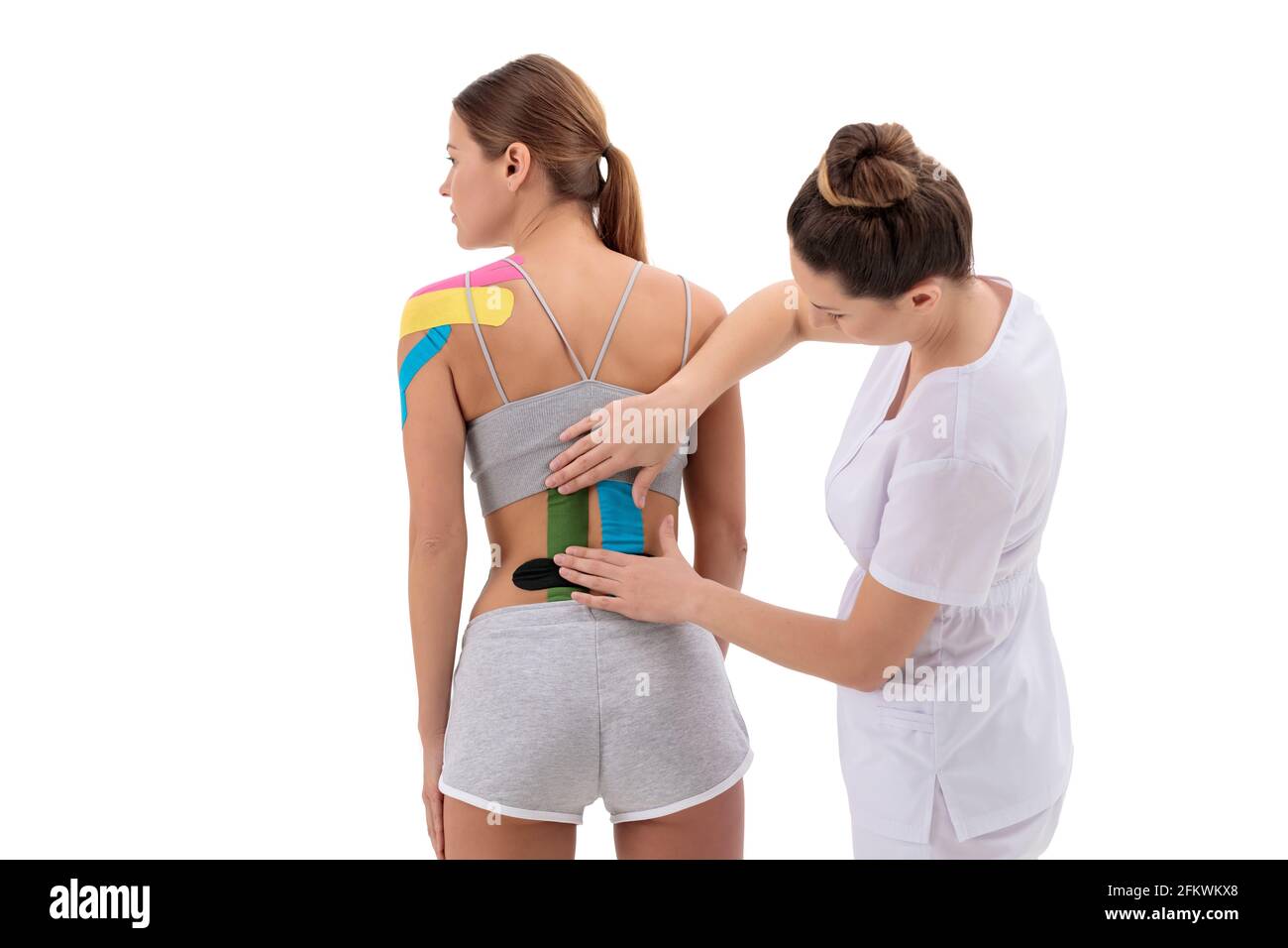 Physiotherapeuten Anwendung kinesio Tape auf der weiblichen Patienten wieder senken. Kinesiologie, Physikalische Therapie, Rehabilitation Konzept. Stockfoto