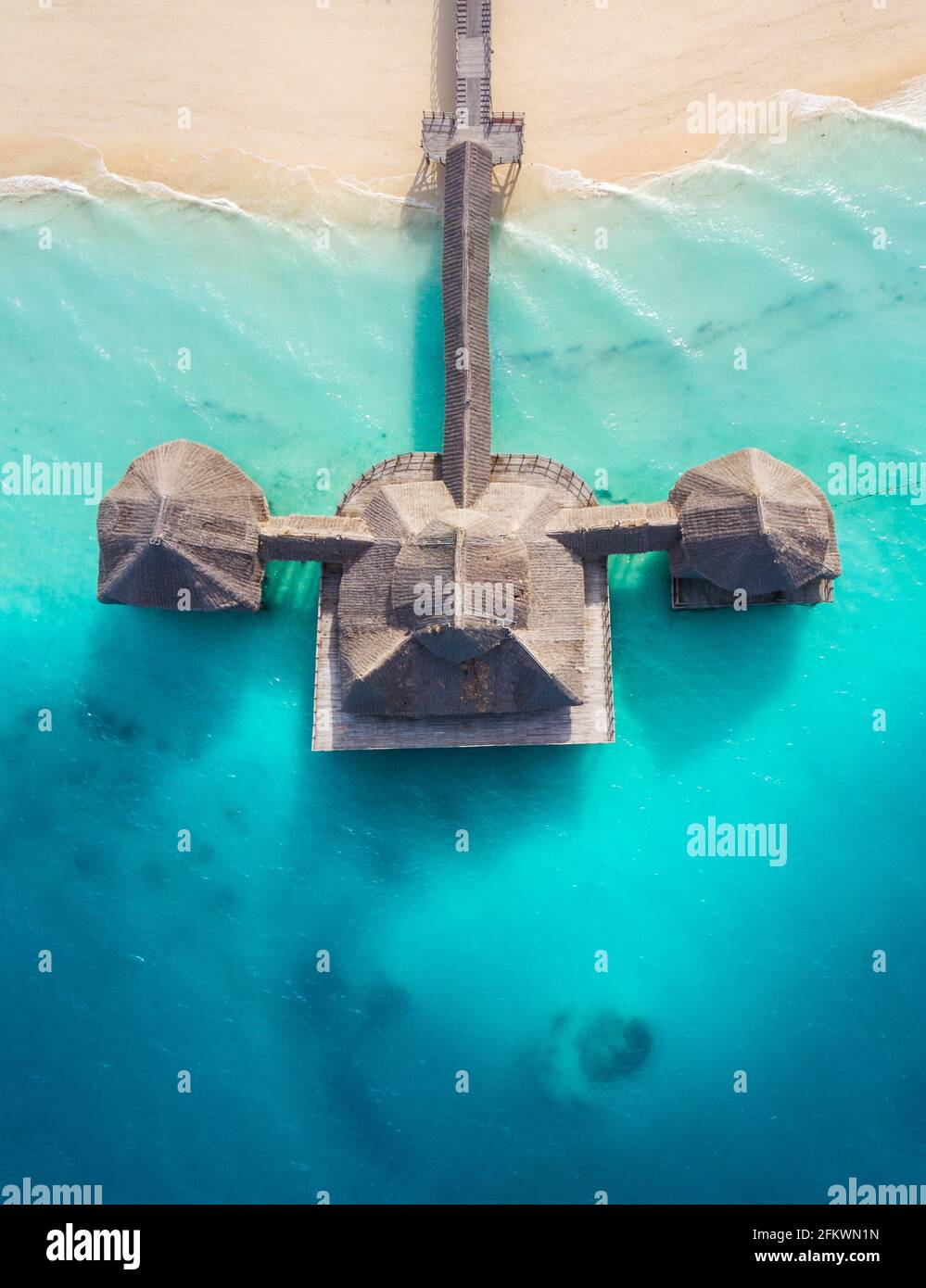 Luftaufnahme der Stilt Hütte mit Palmendach, gewaschen mit türkisfarbenen Wellen des indischen Ozeans, am weißen Sandstrand der Insel Sansibar, Tanza Stockfoto