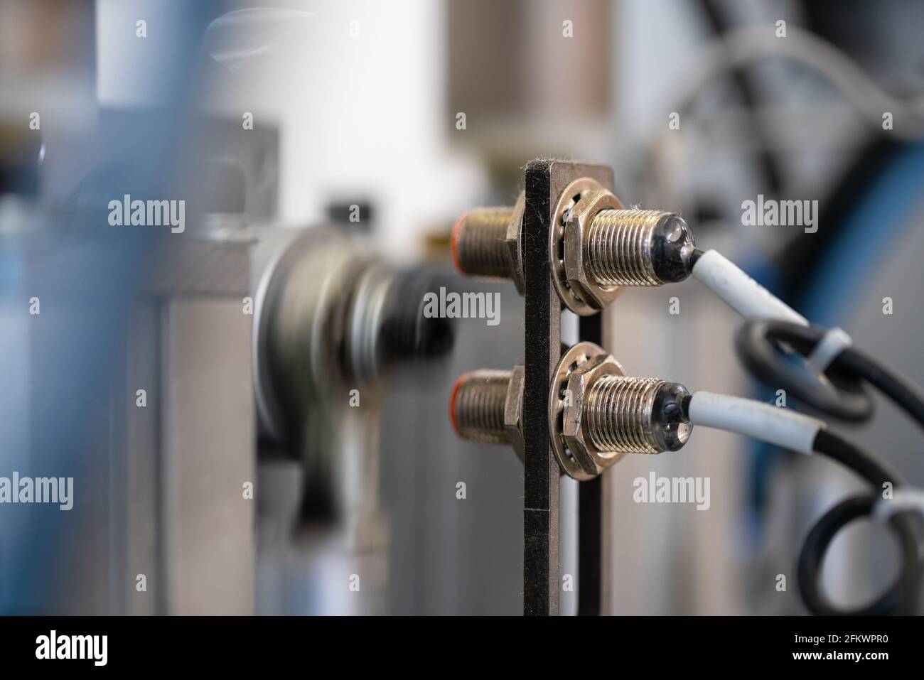 Nahaufnahme des Lasersensors einer Fabrikmaschine. Automatisierte Montagelinie. Stockfoto