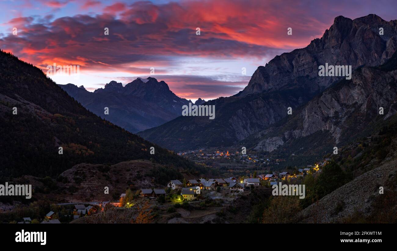 Sonnenuntergang über dem Mont Pelvoux im Massiv des Nationalparks Ecrins und im Dorf Les Vigneaux. Vallouise, Hautes-Alpes, Französische Alpen, Frankreich Stockfoto