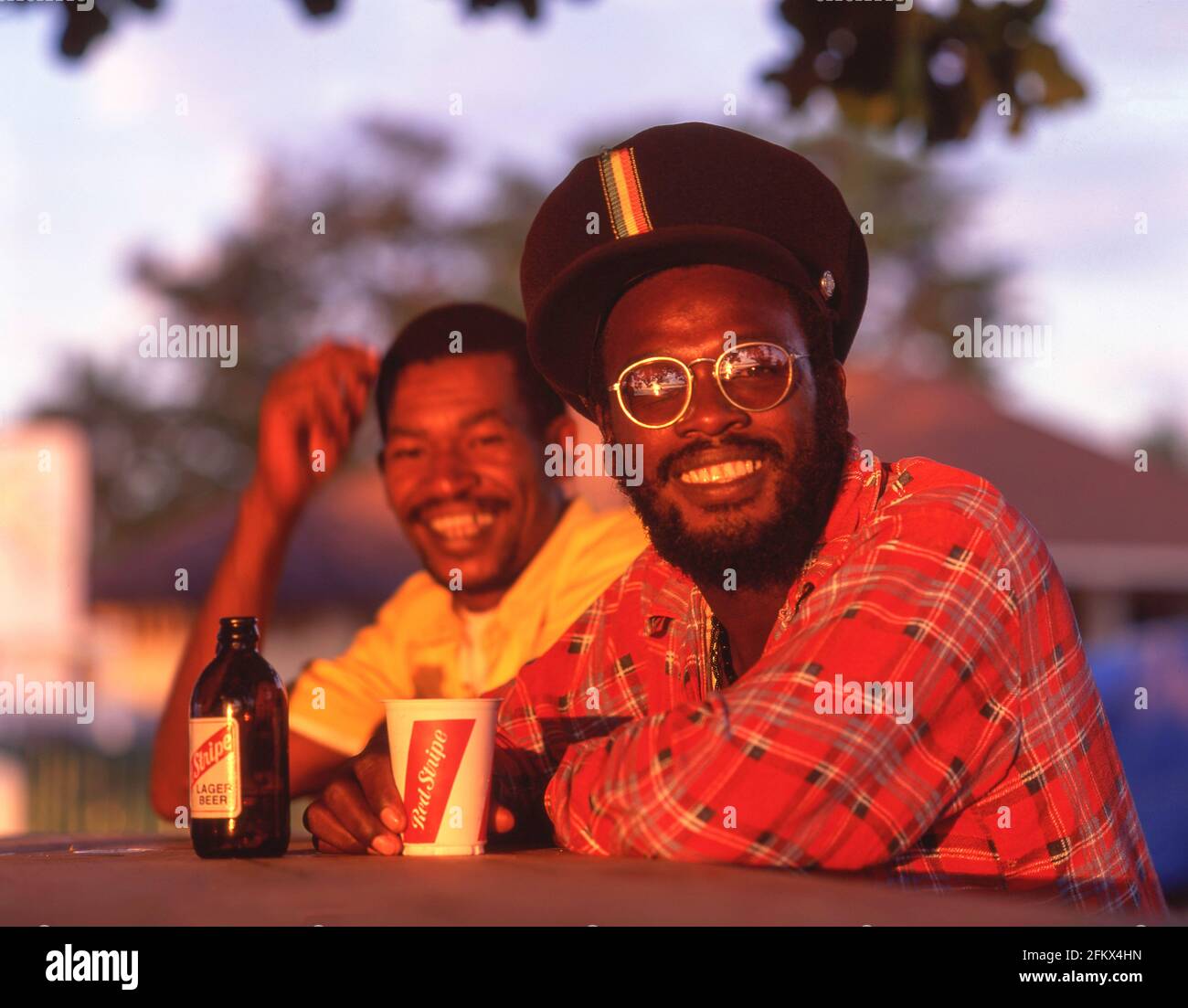 Einheimische Männer trinken Red Stripe Lager in der Außenbar, Ocho Ríos, Saint Ann Parish, Jamaica, Greater Antilles, Karibik Stockfoto