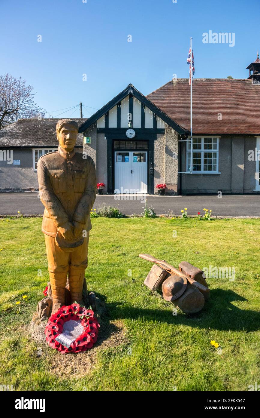 War Memorial Soldier, geschnitzt aus in-situ Baumstumpf, und war Memorial Institute, Ashford-in-the-Water, Derbyshire Stockfoto