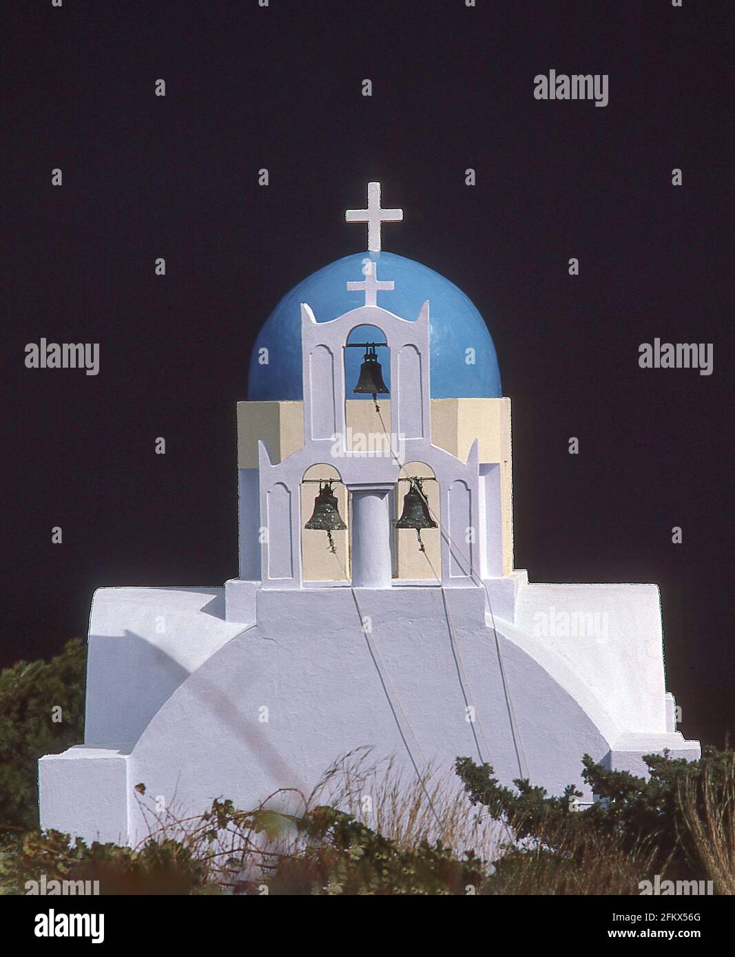 Sonnenbeleuchtete Kirche mit dunklen Sturmwolken dahinter, Fira, Santorini, die Kykladen, Südägäis, Griechenland Stockfoto