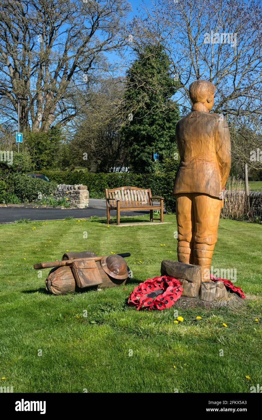 Soldat und Bausatz des Ersten Weltkriegs, geschnitzt aus einem in-situ-Baumstumpf, zum 100. Jahrestag des Endes des Ersten Weltkriegs, Ashford-in-the-Water, Derbyshire Stockfoto