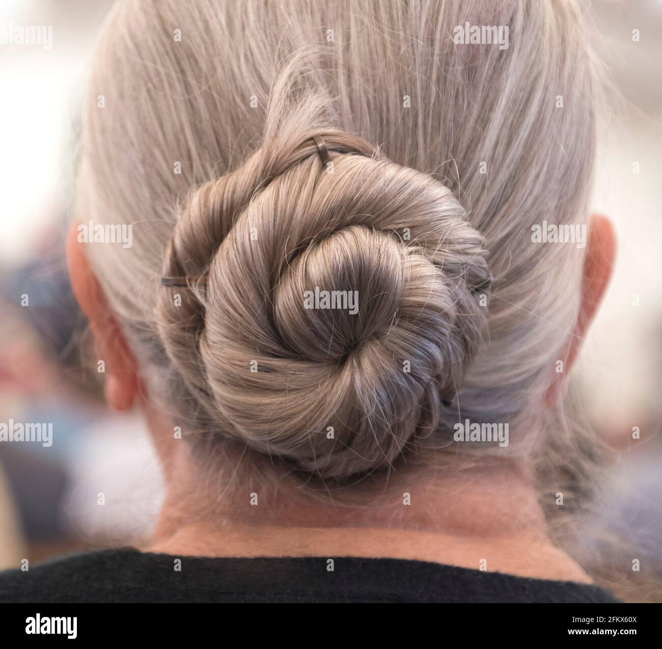 Haare in einem Brötchen bei einer älteren Frau mit grauen Haaren. Stockfoto
