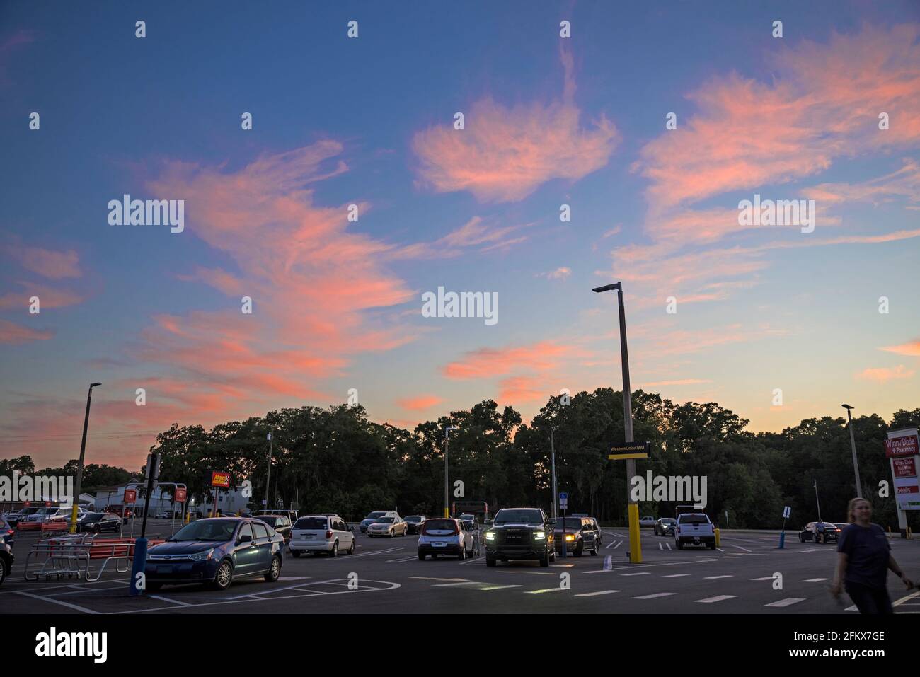 Farbenfrohe Sonnenuntergangswolken über einem Einkaufszentrum in High Springs, Florida. Stockfoto