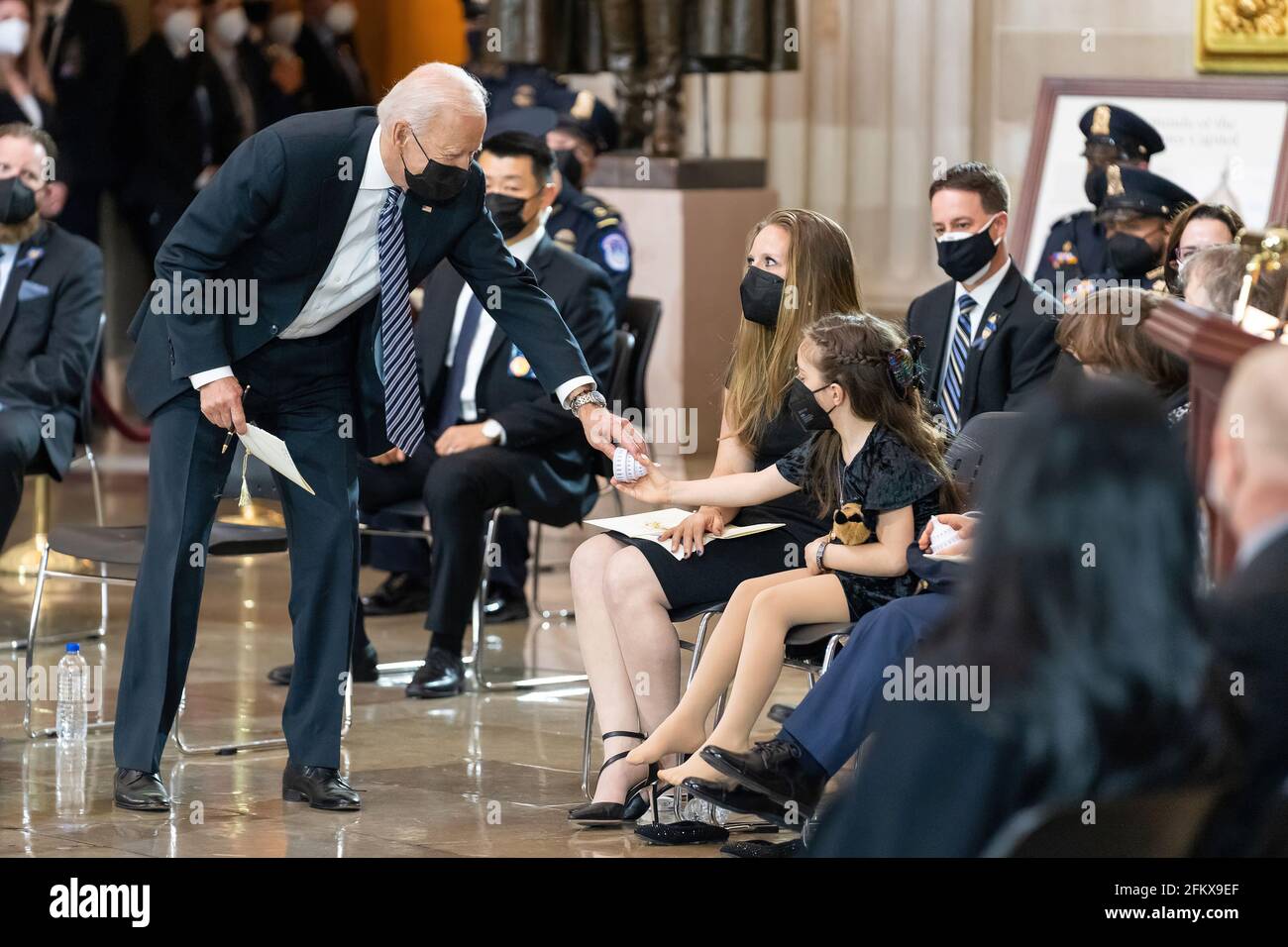 Präsident Joe Biden übergibt der Tochter des gefallenen US-Polizeibeamten William „Bill“ Evans am Dienstag, dem 13. April 2021, in der Rotunde des US-Kapitols in Washington, D.C., eine kleine Figur des Kapitols (Offizielles Foto des Weißen Hauses von Adam Schultz) Stockfoto