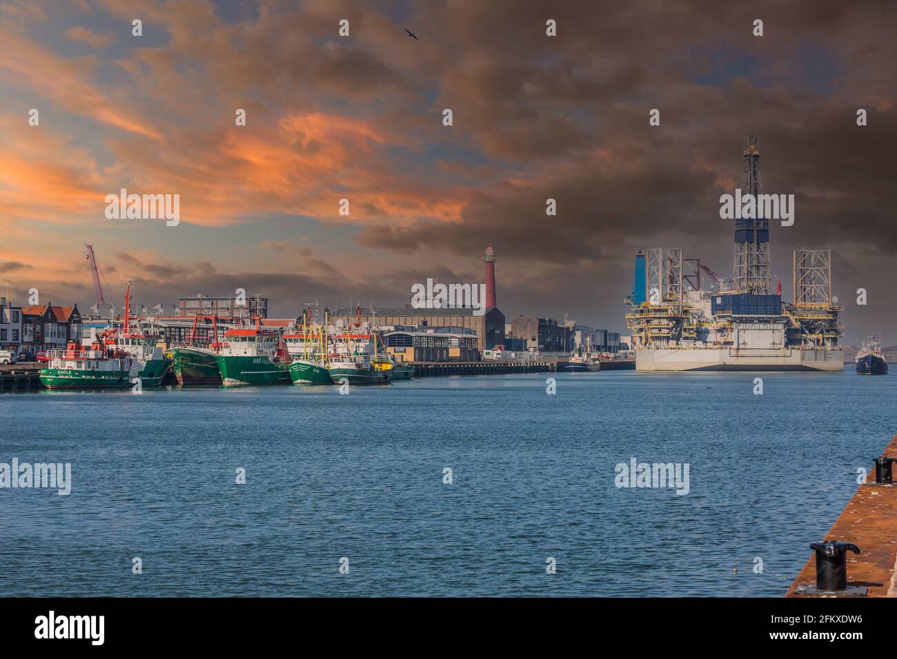 Vissershaven, IJmuiden, Niederlande, 24. März 2021: Verschiedene grüne Schiffe und Ölbohrinseln, die an der Trawlerkade im Außenhafen von IJmui festgemacht wurden Stockfoto