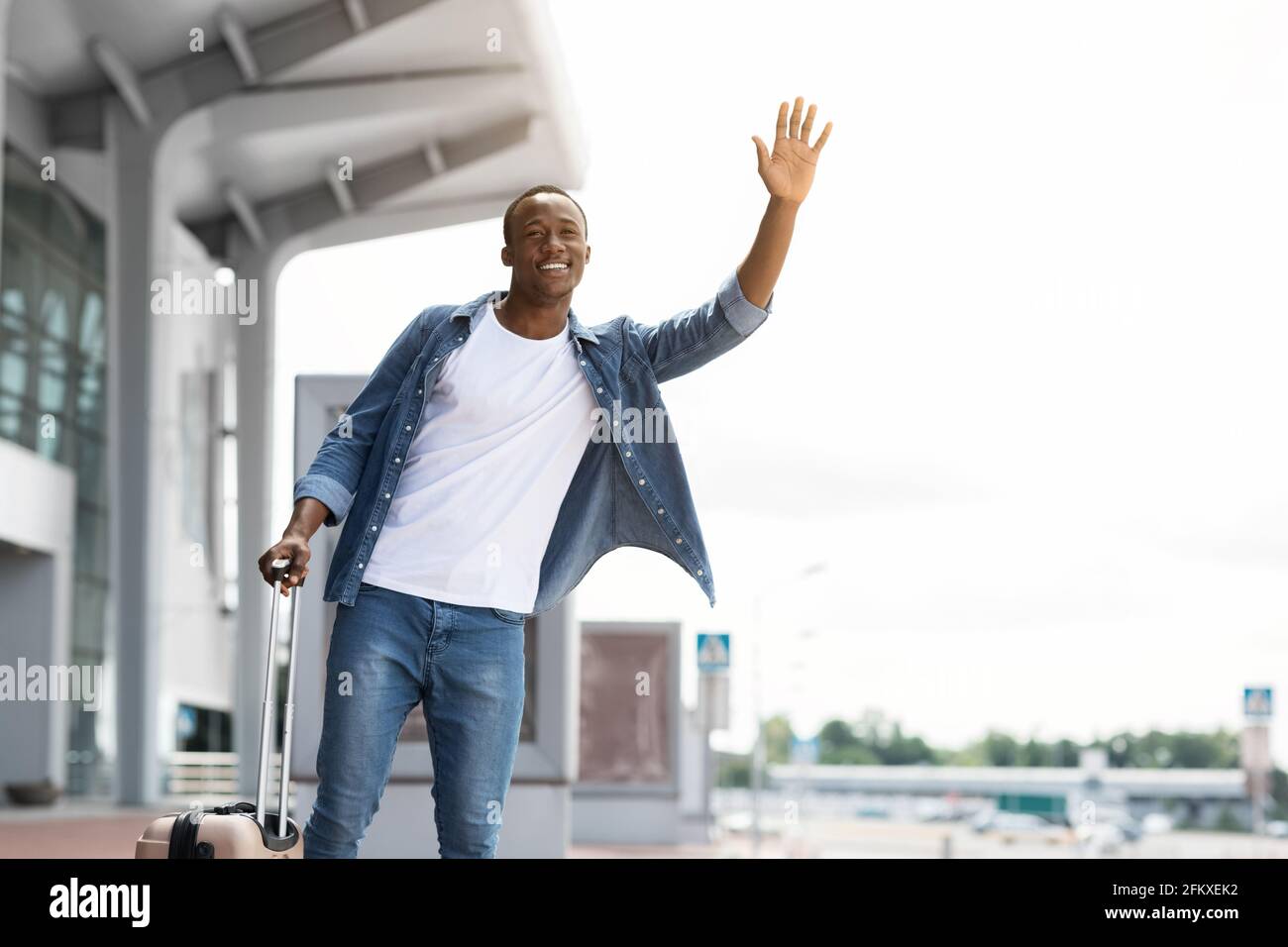 Porträt Von Happy Handsome Black Guy Beim Taxi In Der Nähe Des Flughafens Terminal Stockfoto
