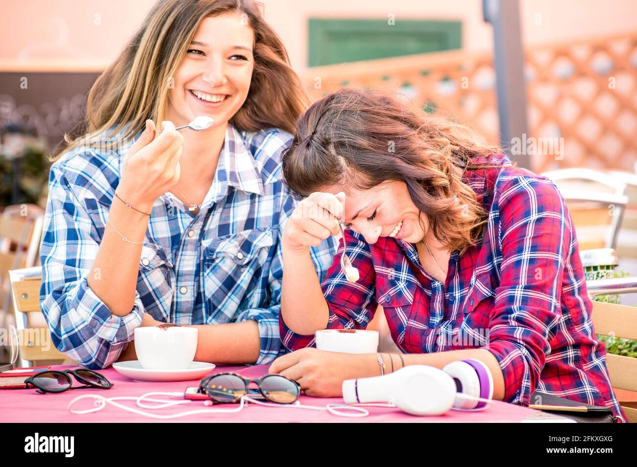 Glücklich paar Freundinnen trinken Cappuccino und lachen zusammen - Glückskonzept mit jungen Frauen reden und Spaß haben Kaffeebar - warm Stockfoto