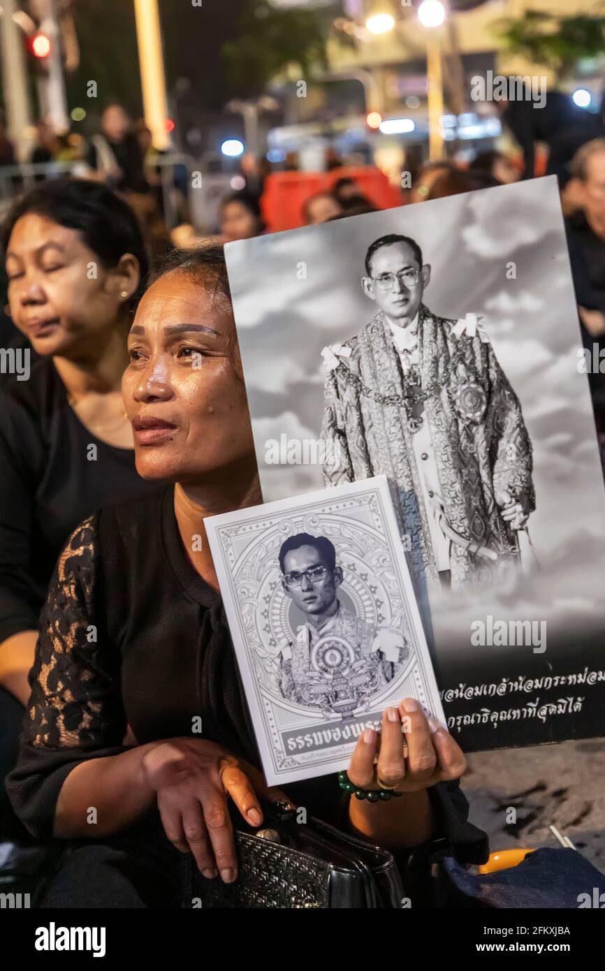 Trauernde in Schwarz mit Fotos von König Bhumibol bei der Trauerfeier in Bangkok, Thailand Stockfoto