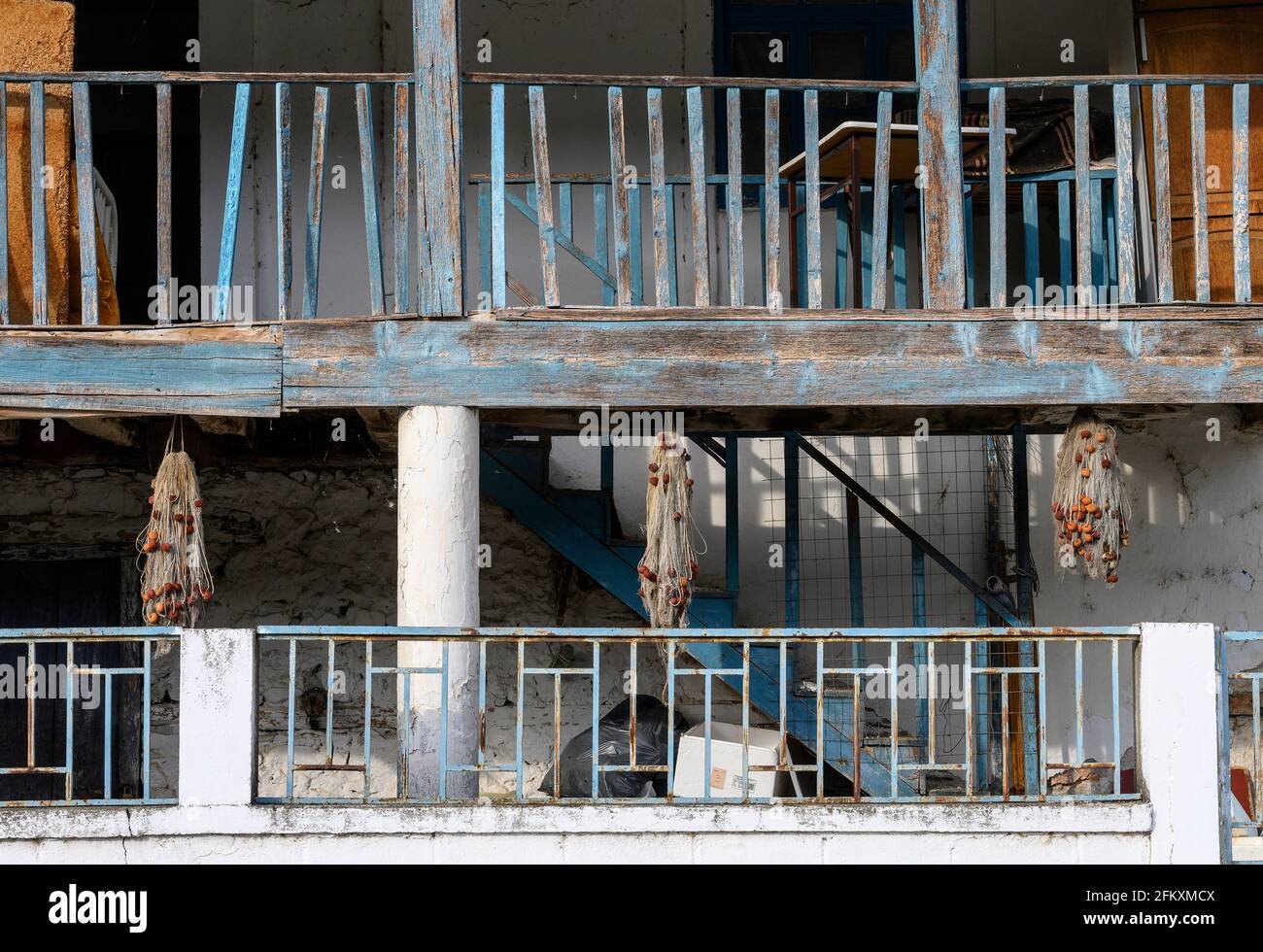 Hölzerne Balkone und Fischernetze im Fischerdorf Psarades am Lake Prespa in Mazedonien, im Norden Griechenlands. Stockfoto