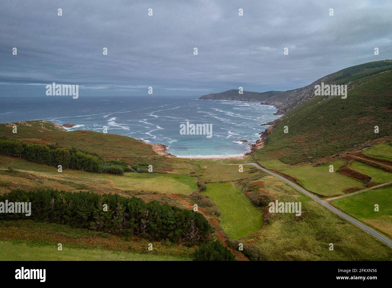 Drohnenansicht eines wilden Strandes mit grüner Landschaft in Galicien, Spanien Stockfoto