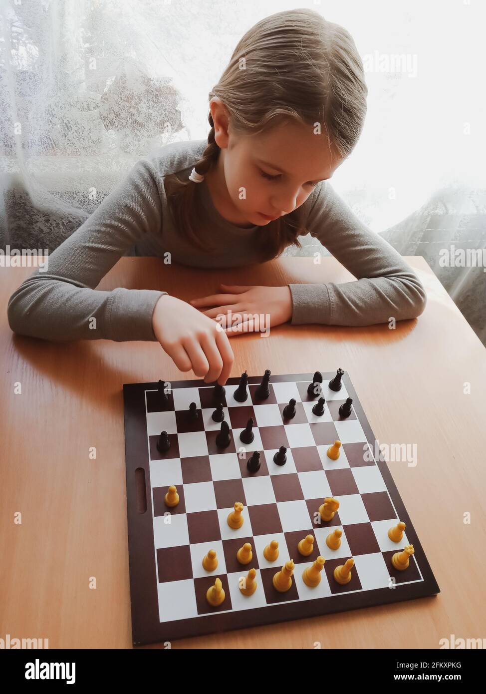 Das Mädchen denkt beim Schachspielen Stockfoto