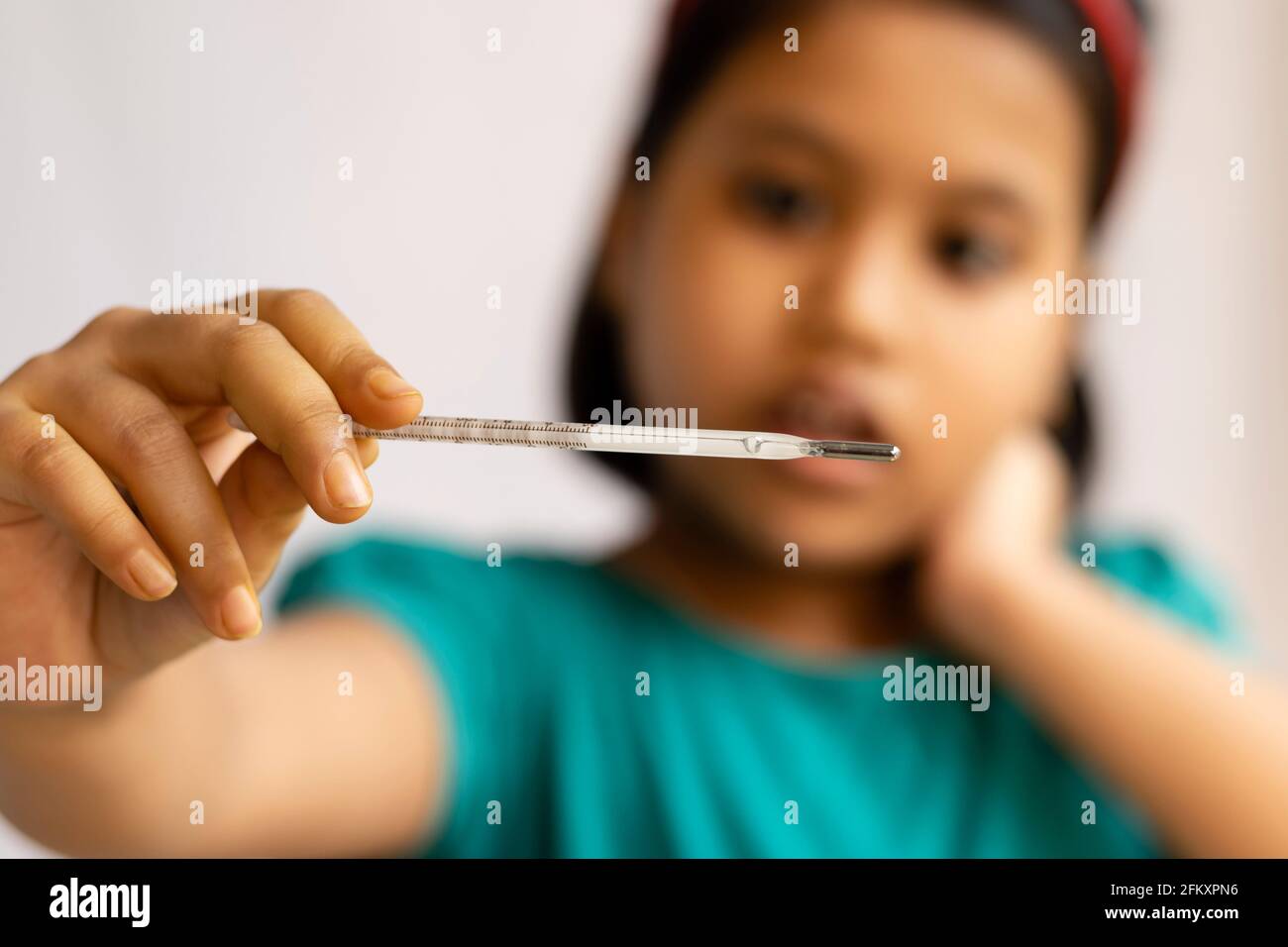 Selektiver Fokus auf ein analoges Thermometer, das in der Hand eines Kindes gehalten wird, Gesundheitskonzept Stockfoto
