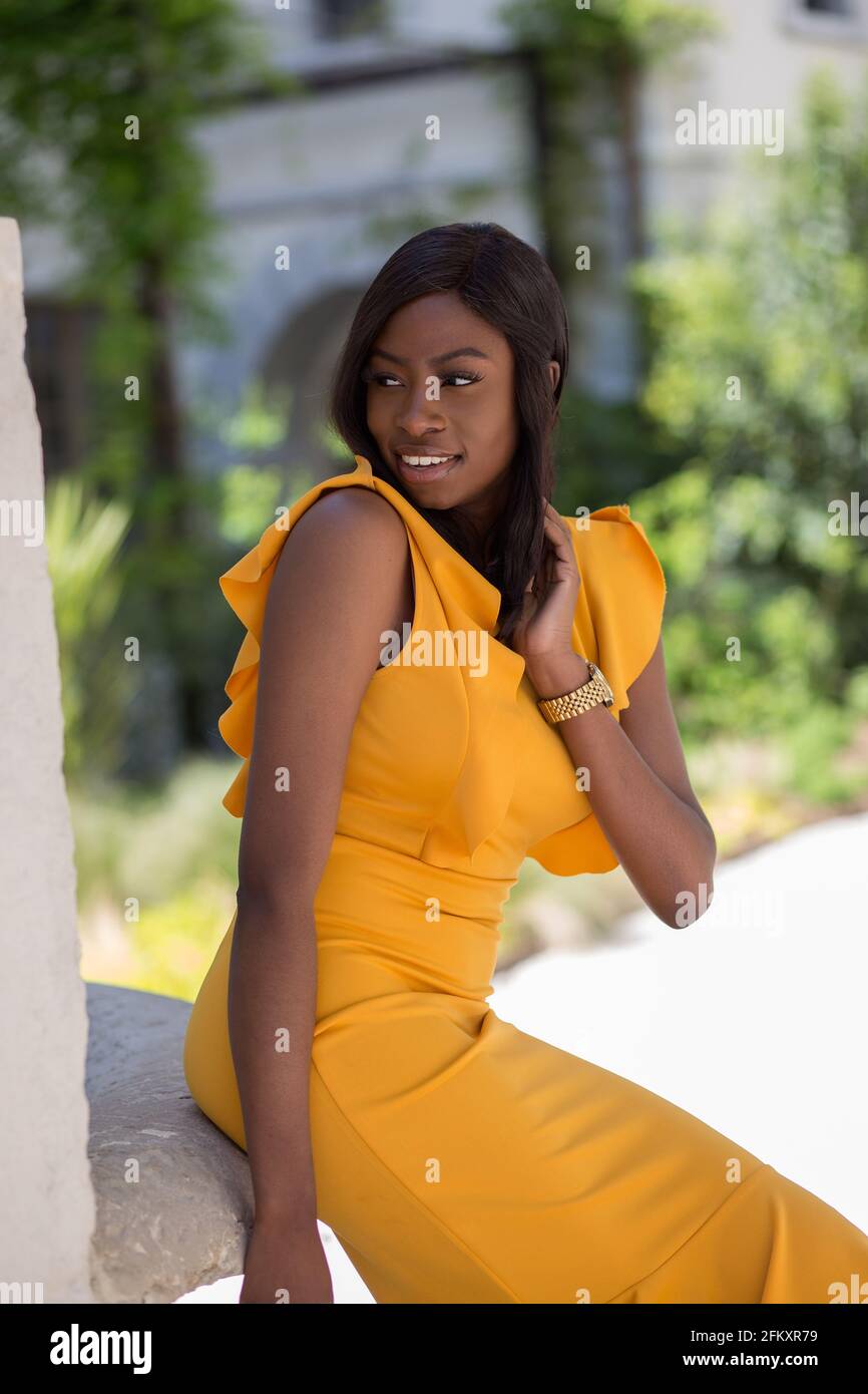 Porträt einer jungen Afro-Frau in den Straßen von lyon frankreich. Gelbes Kleid. Stockfoto
