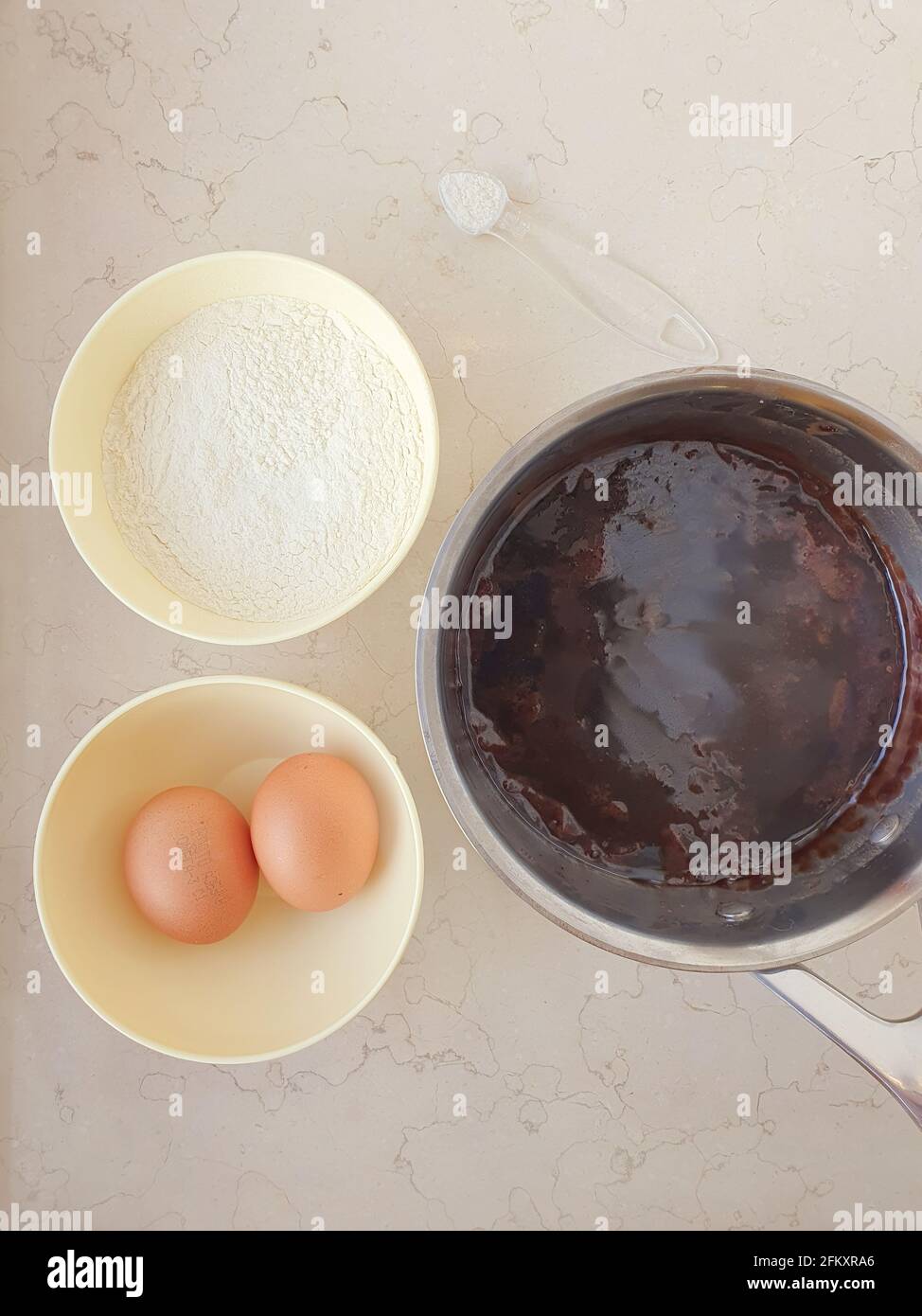 2 Schüsseln und Metalltopf Zutaten Eier Mehl Teig Marmor Flach liegend Stockfoto