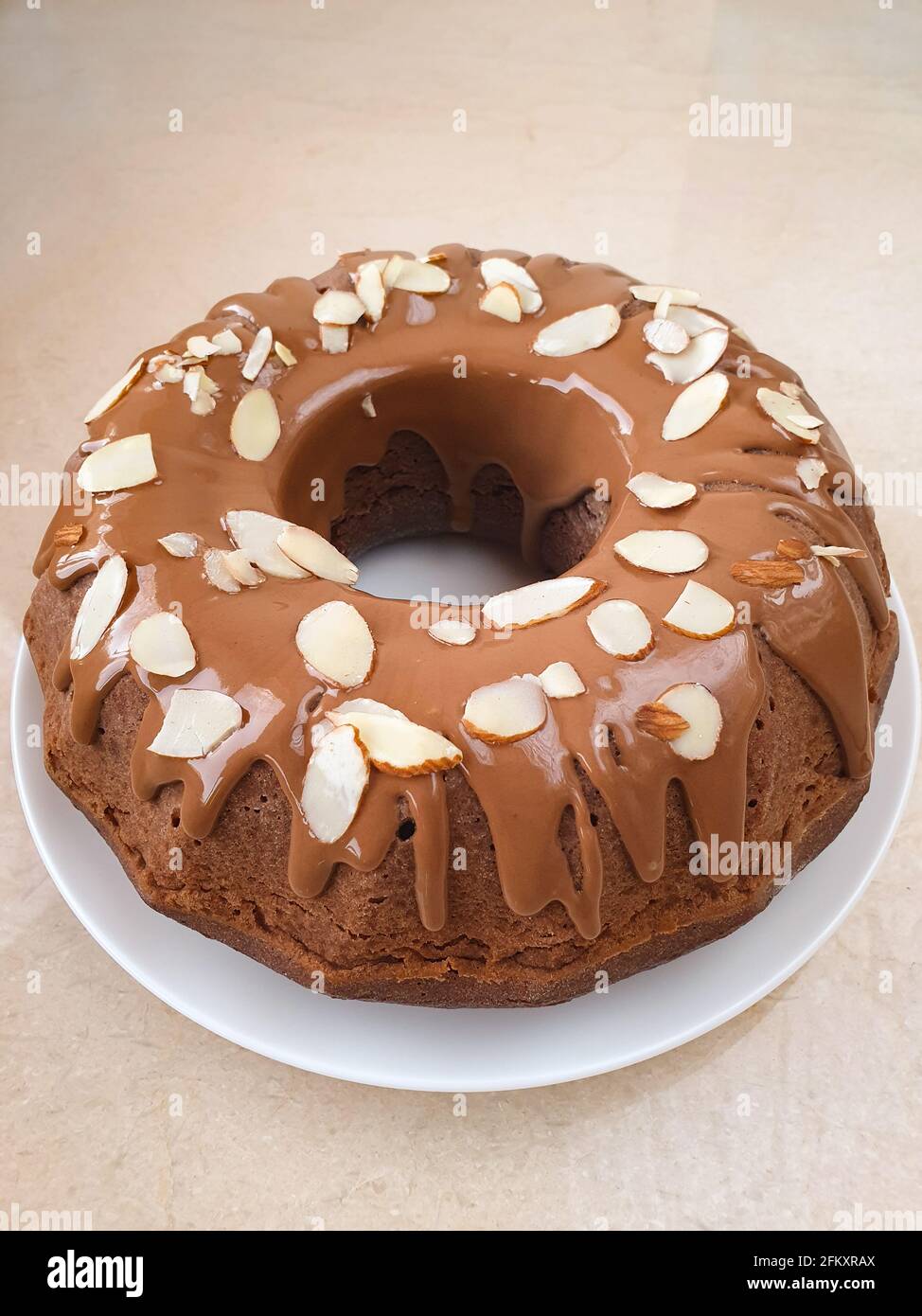 Runde Schokoladenkuchen Mandelblüten auf weißem Marmortisch Stockfoto