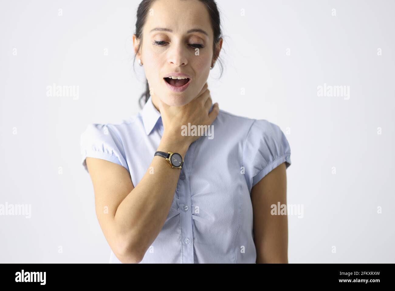 Frustrierte Frau hält ihre Kehle mit der Hand und hustet Stockfoto