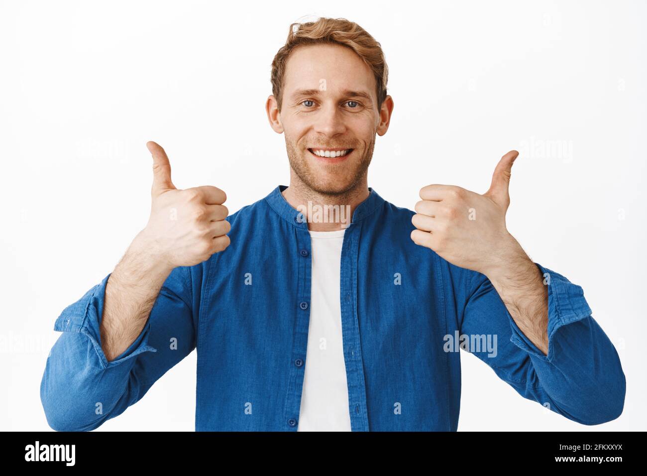 Sehr gut, Gut gemacht. Lächelnder, zufriedener Rotschopf, der die Daumen hoch zeigt, stimmt mit Ihnen überein, sagt Ja zum Vorschlag, klingt gut, steht drüber Stockfoto