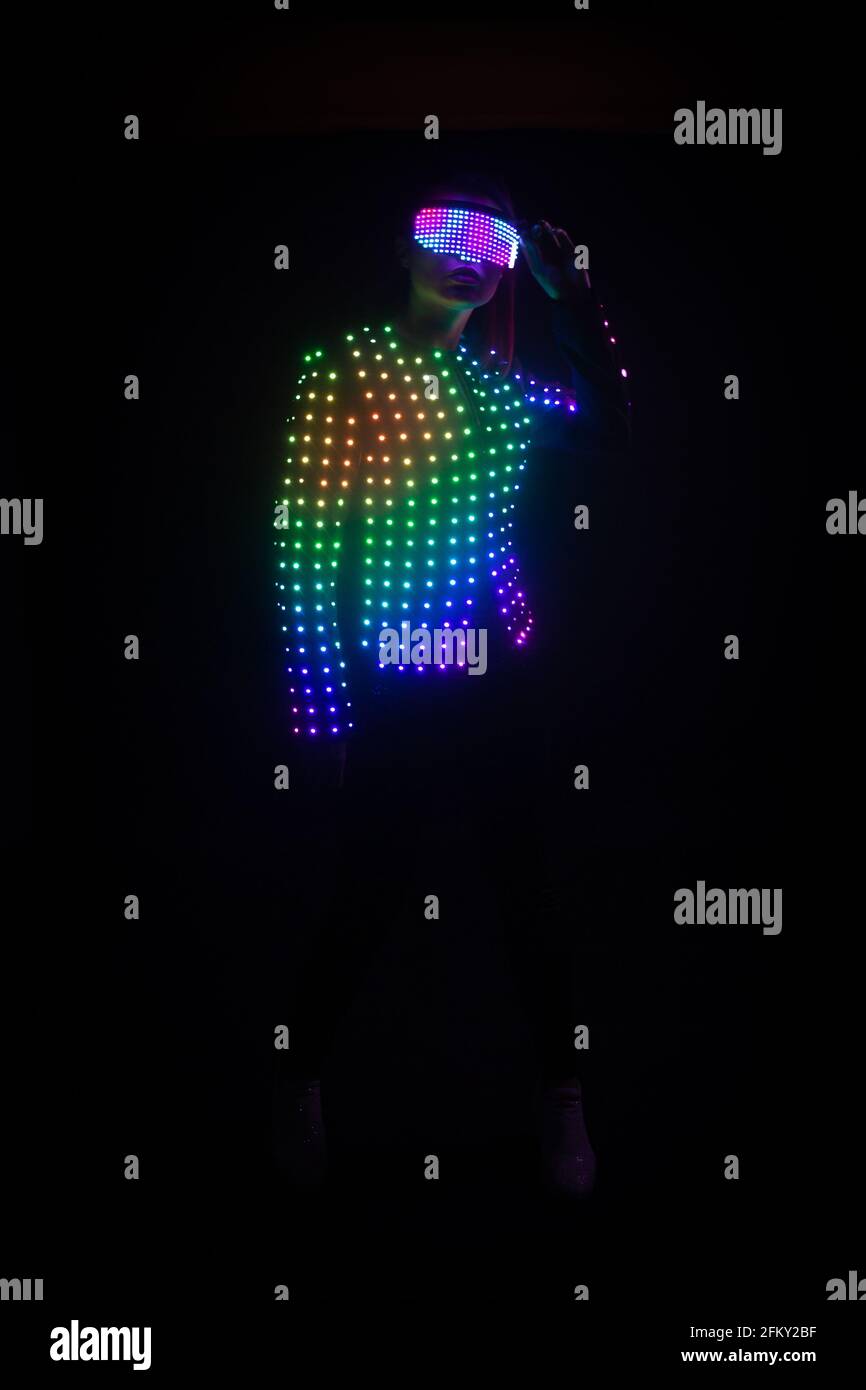 Mädchen in LED-Anzug auf schwarzem Hintergrund Stockfoto