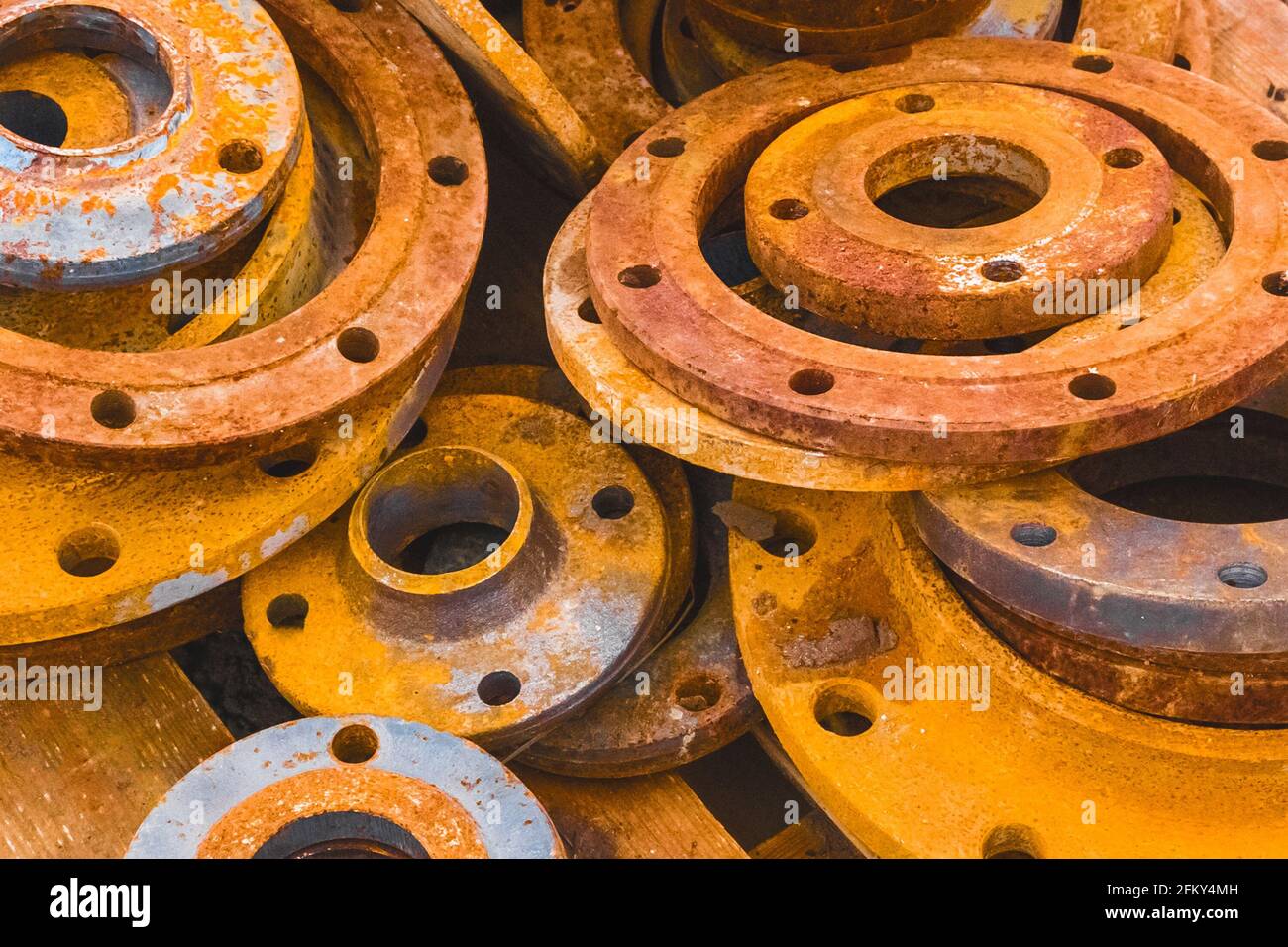 Stapel alter, rostiger industrieller Rohrflansche auf einer Baustelle. Stockfoto