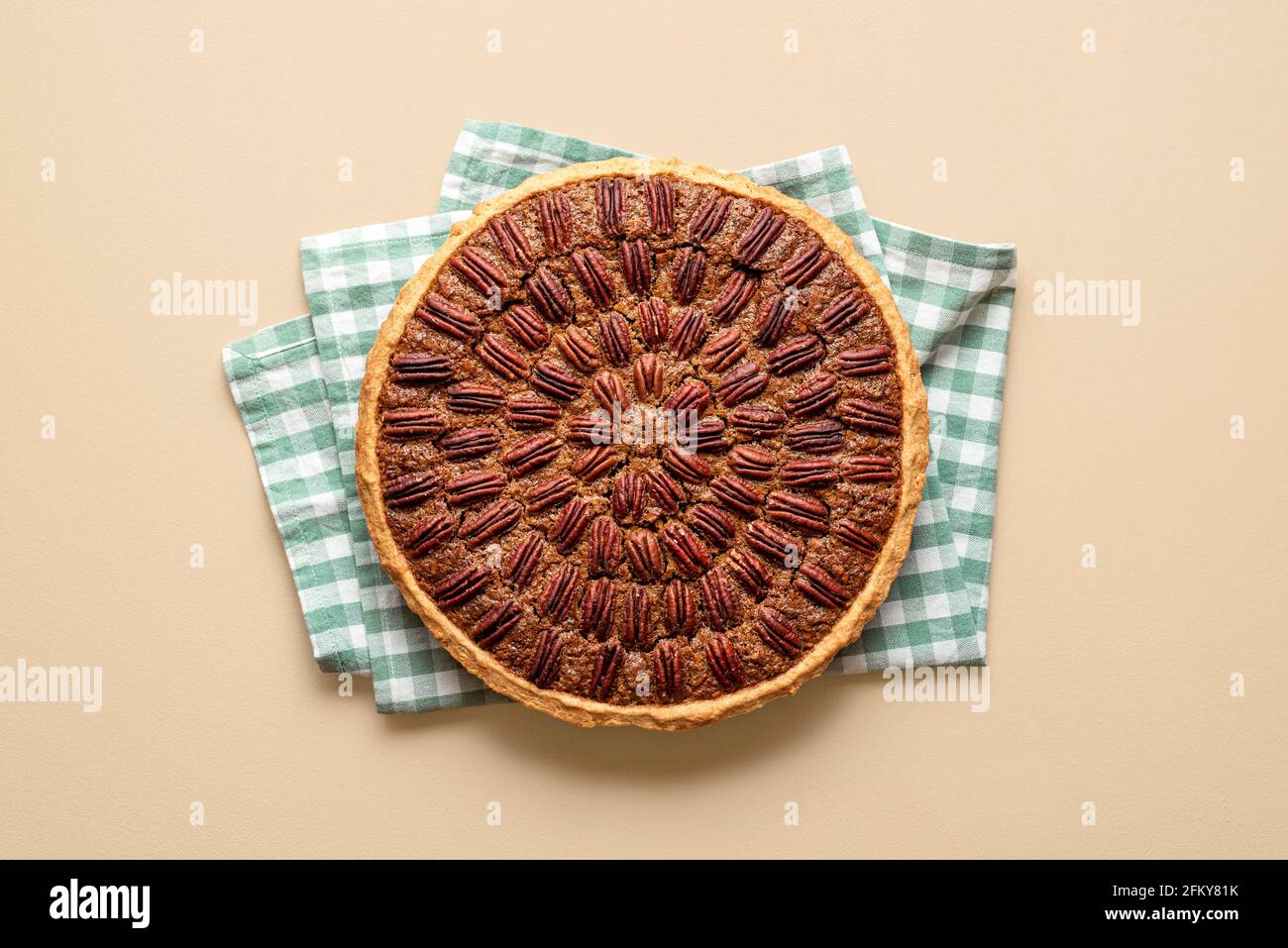 Oben mit einem hausgemachten Pekannüsse auf einem grünen Küchentuch. Frisch gebackener Kuchen mit Pekannüssen und Maissirup. Stockfoto