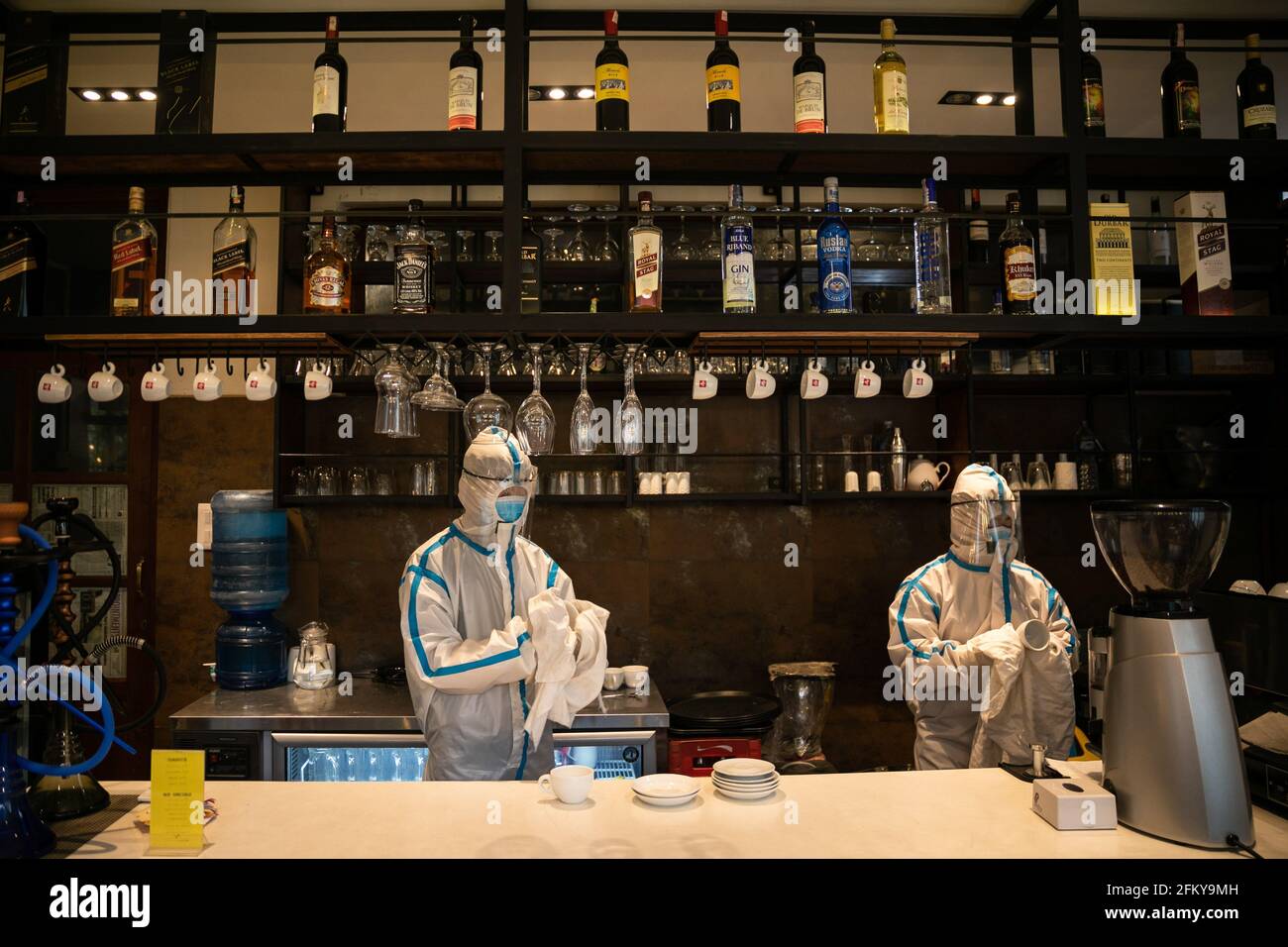 Kathmandu, Nepal. Mai 2021. Ein Mitarbeiter, der persönliche Schutzausrüstung (PSA) trägt und die Oberflächen der Restaurantbar im Hotel Timber House reinigt, das in ein Isolationszentrum für Covid-19-Patienten in benachteiligten oder gefährdeten Situationen in Kathmandu umgewandelt wurde. Nepal bestätigte 7,587 neue Fälle und 55 Todesfälle von COVID-19, was das neue Coronavirus des Landes auf 351,005 anstachelt. (Foto: Prabin Ranabhat/SOPA Images/Sipa USA) Quelle: SIPA USA/Alamy Live News Stockfoto