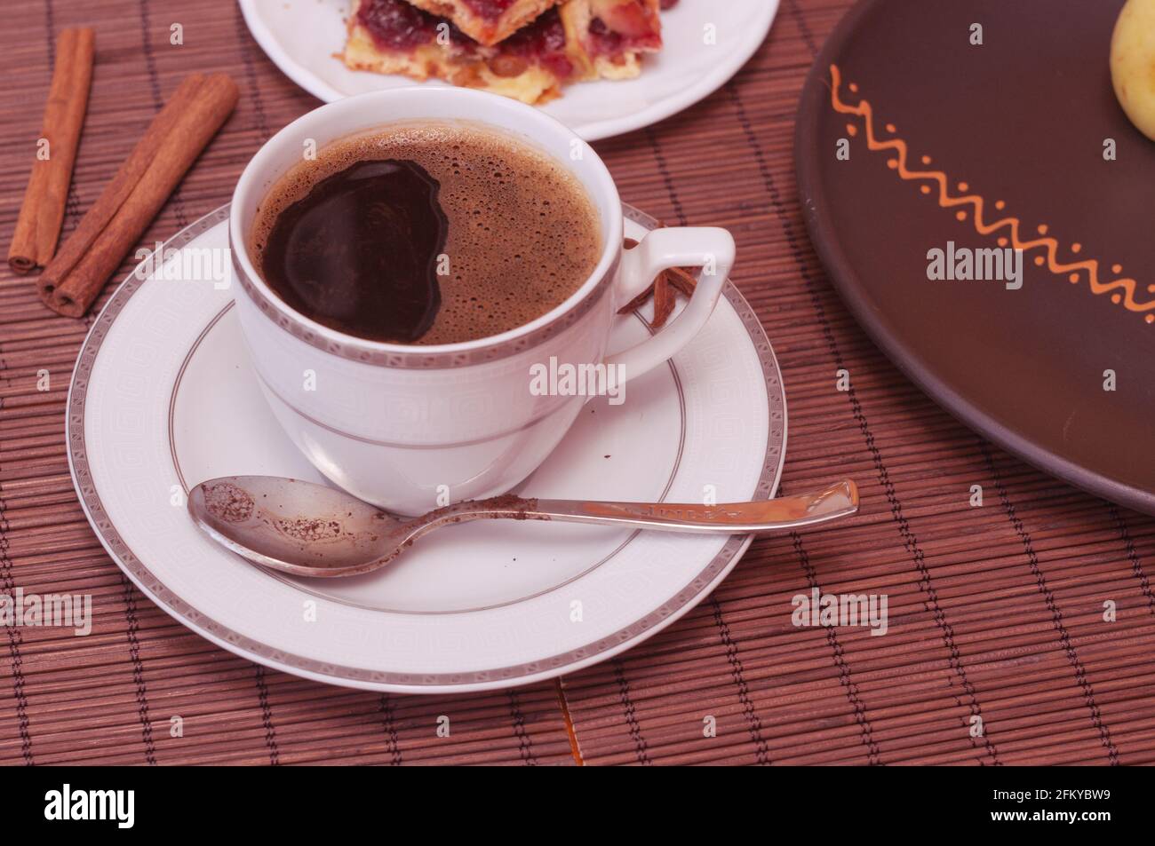 Stillleben - eine Tasse schwarzen Kaffee, hausgemachte Kekse mit Obst auf einer Bambusmatte Stockfoto