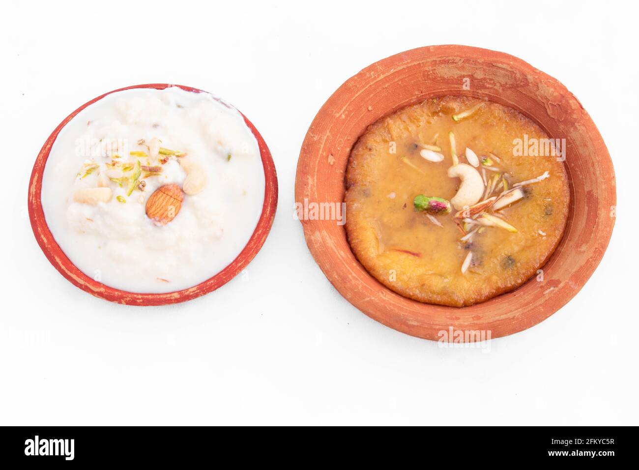 Spezielle Indische Mawa Malpua Mithai In Sugar Syrup Cheeni Eingeweicht Ki Chashni oder Chaashni serviert mit dickem Milch Rabdi oder Rabri In Umweltfreundlicher Terrakotta Stockfoto