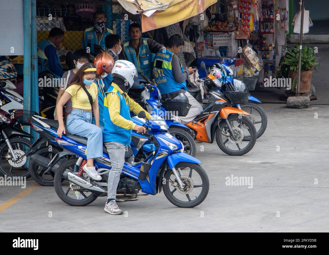 SAMUT PRAKAN, THAILAND, 20 2020. JULI, SITZT EINE junge Frau auf einem Motorrad eines Taxifahrers am Moto-Taxistand Stockfoto